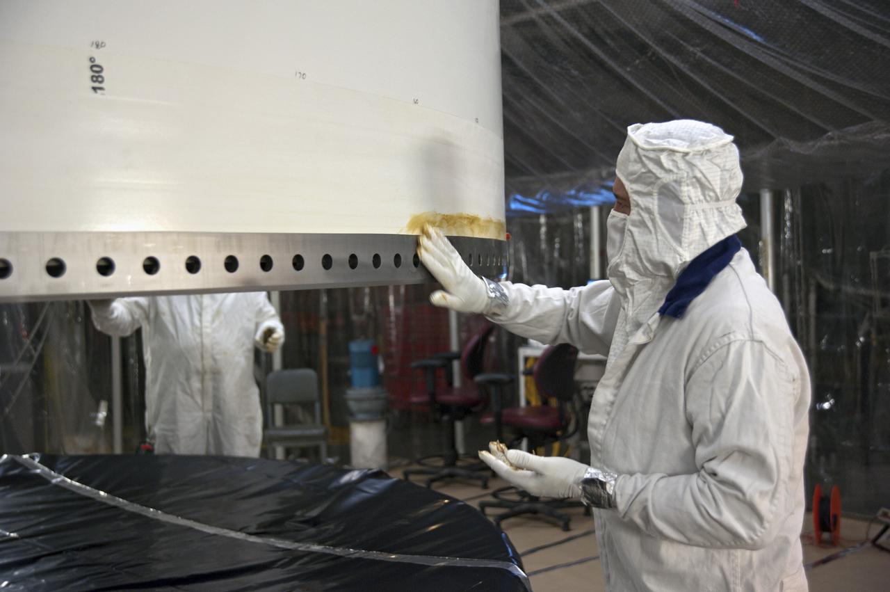 CAPE CANAVERAL, Fla. -- In the Vehicle Assembly Building at NASA's Kennedy Space Center in Florida, a technician is applying HD calcium grease to the field joint along the base of the left forward center solid rocket booster segment to inhibit rust and corrosion from occurring in the area.       The booster along with its twin will be stacked on the mobile launcher platform along with an external fuel tank awaiting the arrival of space shuttle Endeavour for its flight to the International Space Station. As the final planned mission of the Space Shuttle Program, Endeavour and its crew will deliver the Alpha Magnetic Spectrometer, as well as critical spare components to the station on the STS-134 mission targeted for launch Feb. 26, 2011. For more information visit, http://www.nasa.gov/mission_pages/shuttle/shuttlemissions/sts134/index.html. Photo credit: NASA/Kim Shiflett