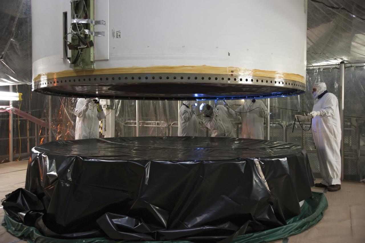 CAPE CANAVERAL, Fla. -- In the Vehicle Assembly Building at NASA's Kennedy Space Center in Florida, technicians install the rubber rings around the circumference of the left forward center solid rocket booster segment before the segments are joined.        The booster along with its twin will be stacked on the mobile launcher platform along with an external fuel tank awaiting the arrival of space shuttle Endeavour for its flight to the International Space Station. As the final planned mission of the Space Shuttle Program, Endeavour and its crew will deliver the Alpha Magnetic Spectrometer, as well as critical spare components to the station on the STS-134 mission targeted for launch Feb. 26, 2011. For more information visit, http://www.nasa.gov/mission_pages/shuttle/shuttlemissions/sts134/index.html. Photo credit: NASA/Kim Shiflett