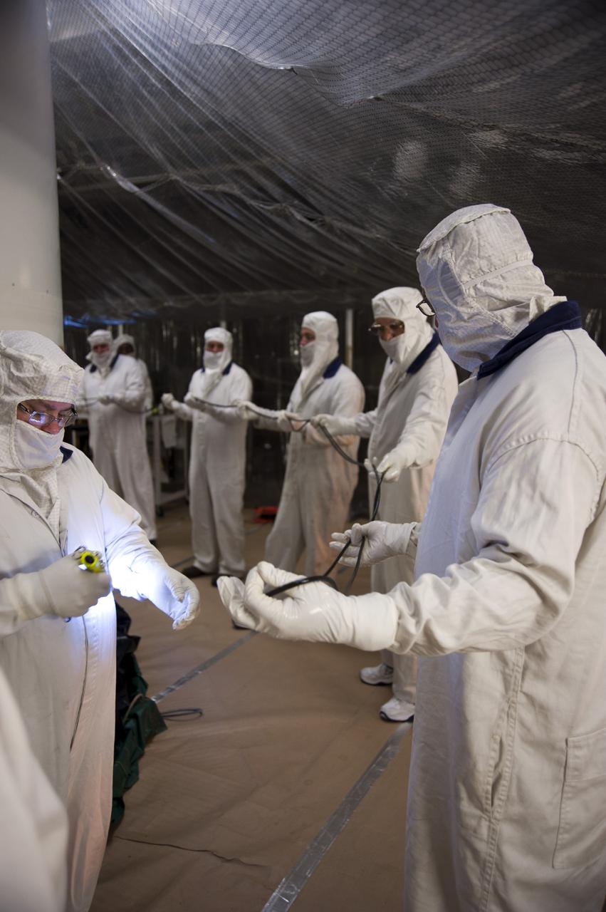 CAPE CANAVERAL, Fla. -- In the Vehicle Assembly Building at NASA's Kennedy Space Center in Florida, workers hold up the rubber rings while another thoroughly inspects each section with an ultraviolet light before the rings are installed on the left forward center solid rocket booster segment.        The booster along with its twin will be stacked on the mobile launcher platform along with an external fuel tank awaiting the arrival of space shuttle Endeavour for its flight to the International Space Station. As the final planned mission of the Space Shuttle Program, Endeavour and its crew will deliver the Alpha Magnetic Spectrometer, as well as critical spare components to the station on the STS-134 mission targeted for launch Feb. 26, 2011. For more information visit, http://www.nasa.gov/mission_pages/shuttle/shuttlemissions/sts134/index.html. Photo credit: NASA/Kim Shiflett