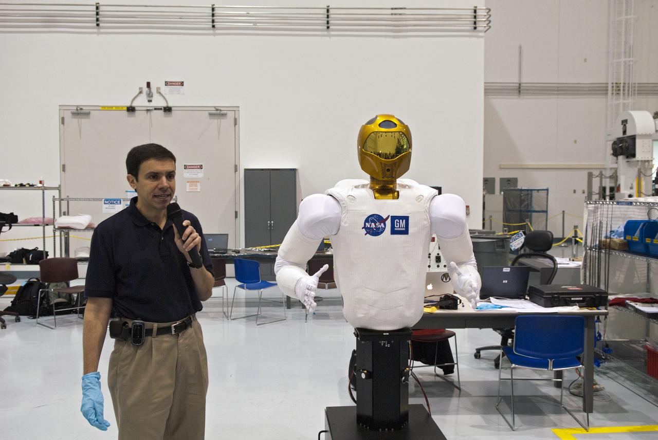 CAPE CANAVERAL, Fla. -- CAPE CANAVERAL, Fla. -- In the Space Station Processing Facility at NASA's Kennedy Space Center in Florida, Ron Diftler, NASA Robonaut project manager, describes the movements of the dexterous humanoid astronaut helper, Robonaut (R2).                R2 will fly to the International Space Station aboard space shuttle Discovery on the STS-133 mission. Although it will initially only participate in operational tests, upgrades could eventually allow the robot to realize its true purpose -- helping spacewalking astronauts with tasks outside the space station. Photo credit: NASA/Jim Grossmann