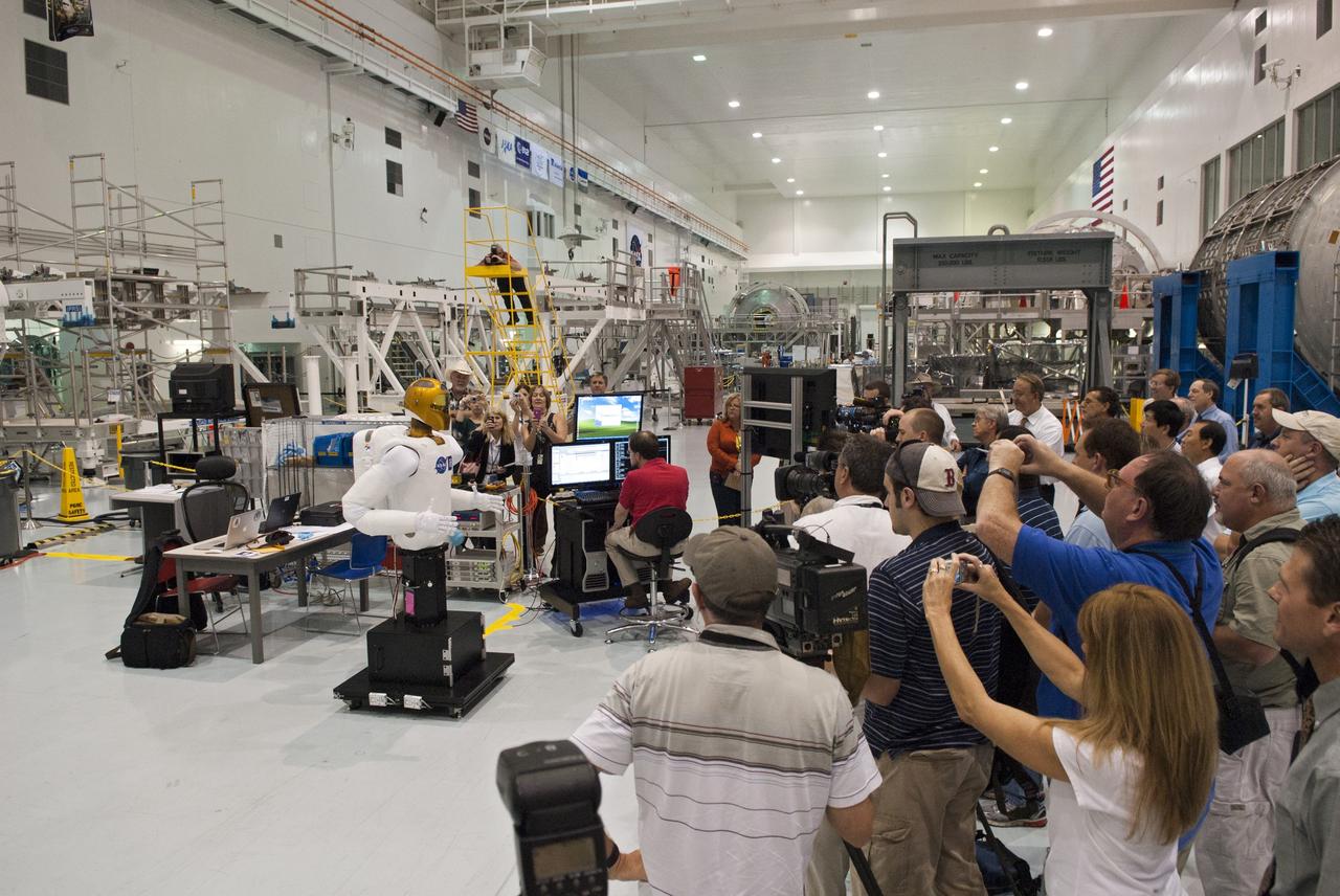 CAPE CANAVERAL, Fla. -- In the Space Station Processing Facility at NASA's Kennedy Space Center in Florida, a robotics engineer animates the dexterous humanoid astronaut helper, Robonaut (R2) for the participants at a media event hosted by NASA.              R2 will fly to the International Space Station aboard space shuttle Discovery on the STS-133 mission. Although it will initially only participate in operational tests, upgrades could eventually allow the robot to realize its true purpose -- helping spacewalking astronauts with tasks outside the space station. Photo credit: NASA/Jim Grossmann