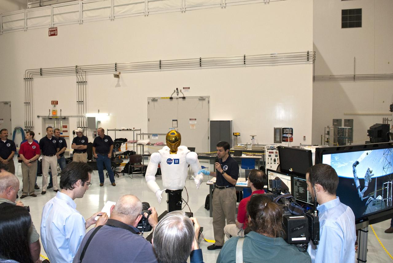 CAPE CANAVERAL, Fla. -- In the Space Station Processing Facility at NASA's Kennedy Space Center in Florida, Ron Diftler, NASA Robonaut project manager explains to the audience how the dexterous humanoid astronaut helper, Robonaut (R2) can be of service while in space.              R2 will fly to the International Space Station aboard space shuttle Discovery on the STS-133 mission. Although it will initially only participate in operational tests, upgrades could eventually allow the robot to realize its true purpose -- helping spacewalking astronauts with tasks outside the space station. Photo credit: NASA/Jim Grossmann