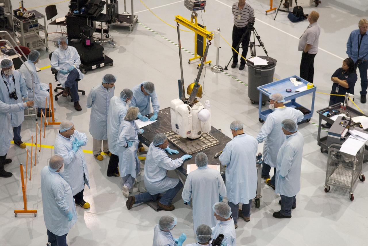 CAPE CANAVERAL, Fla. -- In the Space Station Processing Facility at NASA's Kennedy Space Center in Florida, the dexterous humanoid astronaut helper, Robonaut 2, or R2, is lowered to a base plate, which is part of its launch box called SLEEPR, or Structural Launch Enclosure to Effectively Protect Robonaut.    R2 will fly to the International Space Station aboard space shuttle Discovery on the STS-133 mission. Although it will initially only participate in operational tests, upgrades could eventually allow the robot to realize its true purpose -- helping spacewalking astronauts with tasks outside the space station. Photo credit: NASA/Frankie Martin