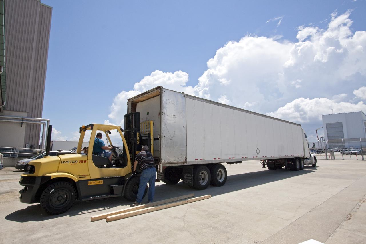CAPE CANAVERAL, Fla. -- In the Space Station Processing Facility at NASA's Kennedy Space Center in Florida, a forklift moves shipping containers packed with tools and flight support equipment for orbital replacement units into a tractor-trailer for their trip to the Japanese Aerospace Exploration Agency's Tanegashima Space Center. There, the six units, including the flex hose rotary coupler, will be processed for launch to the International Space Station aboard HTV-2, scheduled for Jan. 20, 2011.    HTV-2 is an uncrewed cargo transporter that will be launched by the H-IIB launch vehicle. It is designed to deliver up to 6 tons of supplies, including food, clothes and experiment devices to the space station. Photo credit: NASA/Jack Pfaller