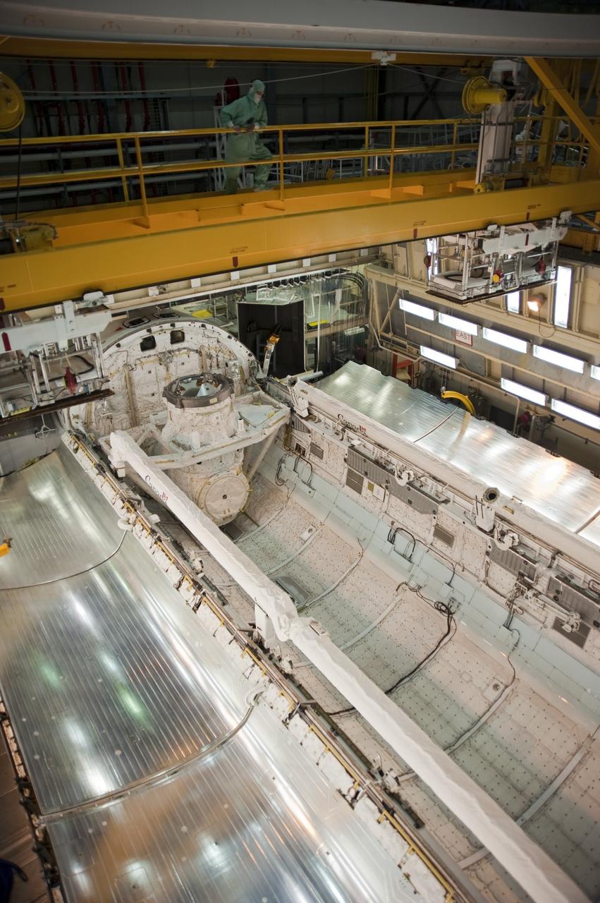 CAPE CANAVERAL, Fla. -- In Orbiter Processing Facility-3 at NASA's Kennedy Space Center in Florida, the clamshell doors of space shuttle Discovery's payload bay begin to close in preparation for the its move  to the Vehicle Assembly Building next month. There, it will be attached to its external fuel tank and a set of solid rocket boosters for launch on the STS-133 mission to the International Space Station.    Targeted to launch Nov. 1, STS-133 will carry the multipurpose logistics module, or PMM, packed with supplies and critical spare parts, as well as Robonaut 2, or R2, to the station. Discovery will leave the module behind so it can be used for microgravity experiments in fluid physics, materials science, biology and biotechnology. Photo credit: NASA/Kim Shiflett