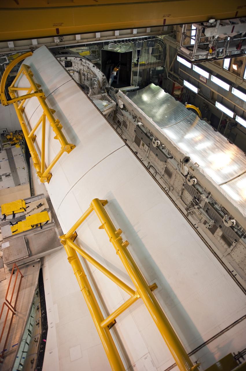CAPE CANAVERAL, Fla. -- In Orbiter Processing Facility-3 at NASA's Kennedy Space Center in Florida, the clamshell doors of space shuttle Discovery's payload bay begin to close in preparation for the its move  to the Vehicle Assembly Building next month. There, it will be attached to its external fuel tank and a set of solid rocket boosters for launch on the STS-133 mission to the International Space Station.    Targeted to launch Nov. 1, STS-133 will carry the multipurpose logistics module, or PMM, packed with supplies and critical spare parts, as well as Robonaut 2, or R2, to the station. Discovery will leave the module behind so it can be used for microgravity experiments in fluid physics, materials science, biology and biotechnology. Photo credit: NASA/Kim Shiflett