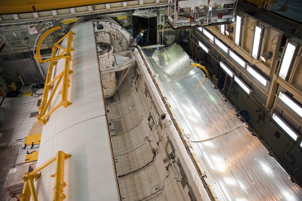 CAPE CANAVERAL, Fla. -- In Orbiter Processing Facility-3 at NASA's Kennedy Space Center in Florida, the clamshell doors of space shuttle Discovery's payload bay begin to close in preparation for the its move  to the Vehicle Assembly Building next month. There, it will be attached to its external fuel tank and a set of solid rocket boosters for launch on the STS-133 mission to the International Space Station.    Targeted to launch Nov. 1, STS-133 will carry the multipurpose logistics module, or PMM, packed with supplies and critical spare parts, as well as Robonaut 2, or R2, to the station. Discovery will leave the module behind so it can be used for microgravity experiments in fluid physics, materials science, biology and biotechnology. Photo credit: NASA/Kim Shiflett