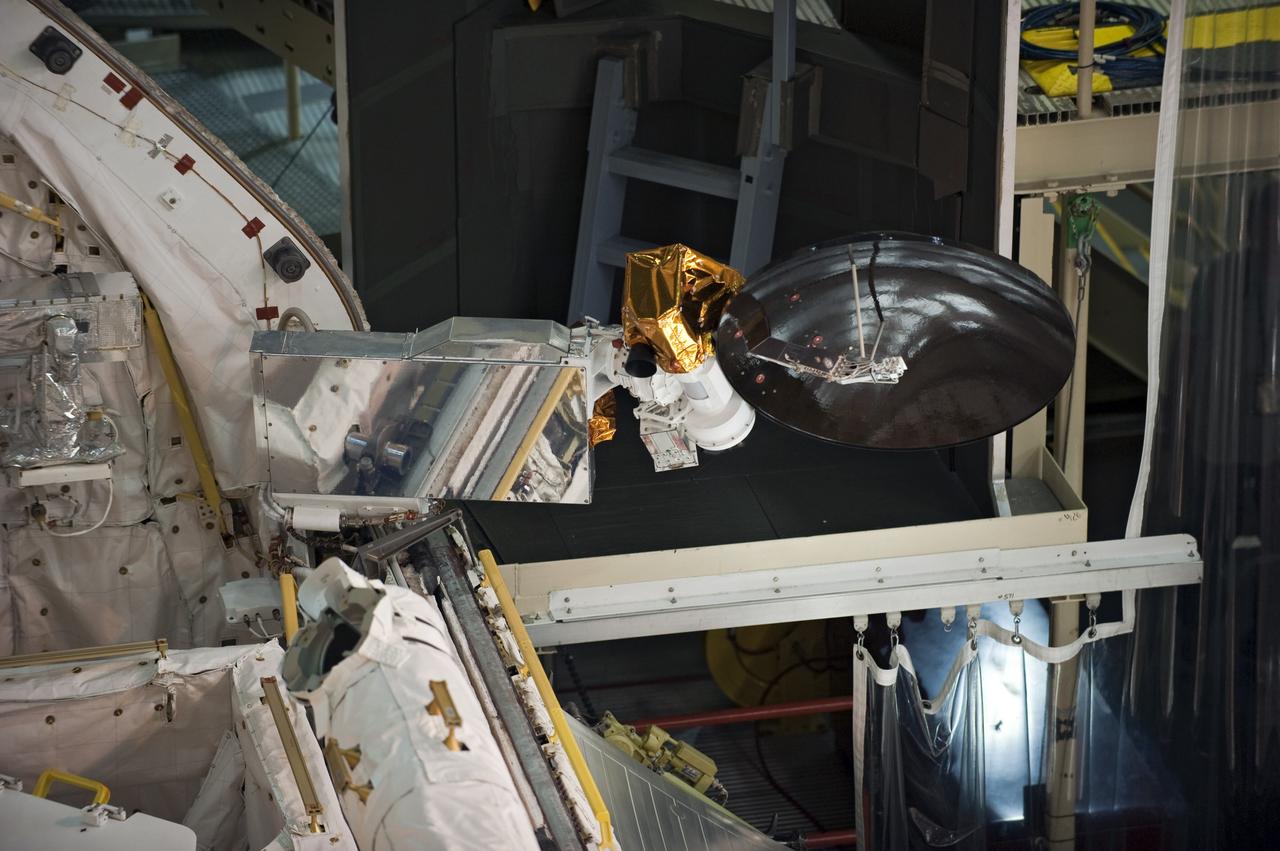 CAPE CANAVERAL, Fla. -- In Orbiter Processing Facility-3 at NASA's Kennedy Space Center in Florida, the Ku-band antenna is stored in space shuttle Discovery's payload bay. The antenna, which resembles a mini-satellite dish, transmits audio, video and data between Earth and the shuttle. Next, the clamshell doors of the payload bay will close completely in preparation for its move to the Vehicle Assembly Building next month. There, it will be attached to its external fuel tank and a set of solid rocket boosters for launch on the STS-133 mission to the International Space Station.    Targeted to launch Nov. 1, STS-133 will carry the multipurpose logistics module, or PMM, packed with supplies and critical spare parts, as well as Robonaut 2, or R2, to the station. Discovery will leave the module behind so it can be used for microgravity experiments in fluid physics, materials science, biology and biotechnology. Photo credit: NASA/Kim Shiflett