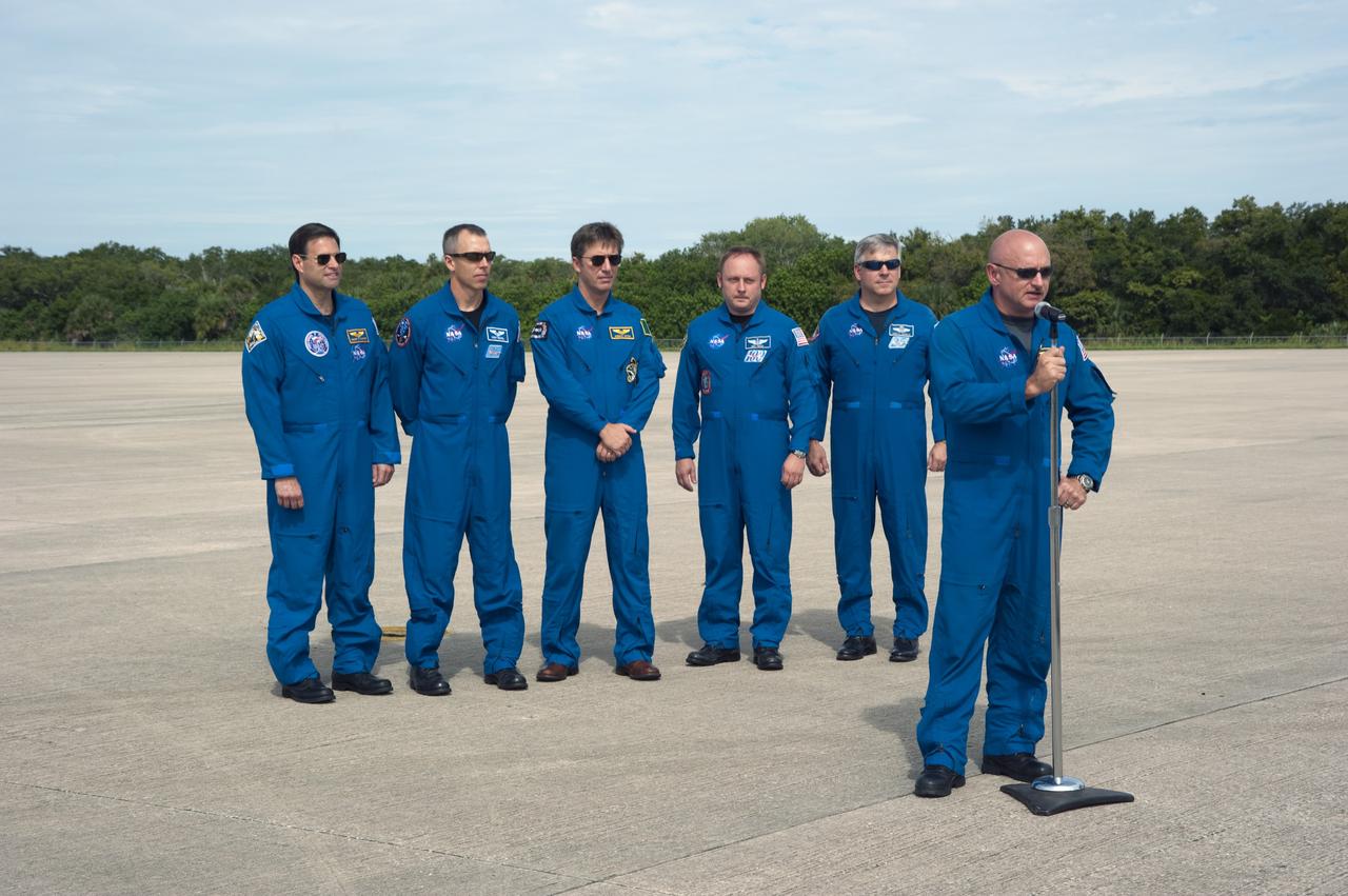 CAPE CANAVERAL, Fla. -- At the Shuttle Landing Facility at NASA's Kennedy Space Center in Florida, the STS-134 crew is on hand for the arrival of the Alpha Magnetic Spectrometer, or AMS. At the microphone is Commander Mark Kelly and left to right are Mission Specialists Greg Chamitoff, Andrew Feustel, European Space Agency astronaut Roberto Vittori, Mission Specialist Michael Fincke and Pilot Gregory H. Johnson. AMS is a state-of-the-art particle physics detector is designed to operate as an external module on the International Space Station. It will use the unique environment of space to study the universe and its origin by searching for dark matter. AMS will fly to the International Space Station aboard space shuttle Endeavour's STS-134 mission targeted to launch Feb. 26, 2011. Photo credit: NASA/Kim Shiflett