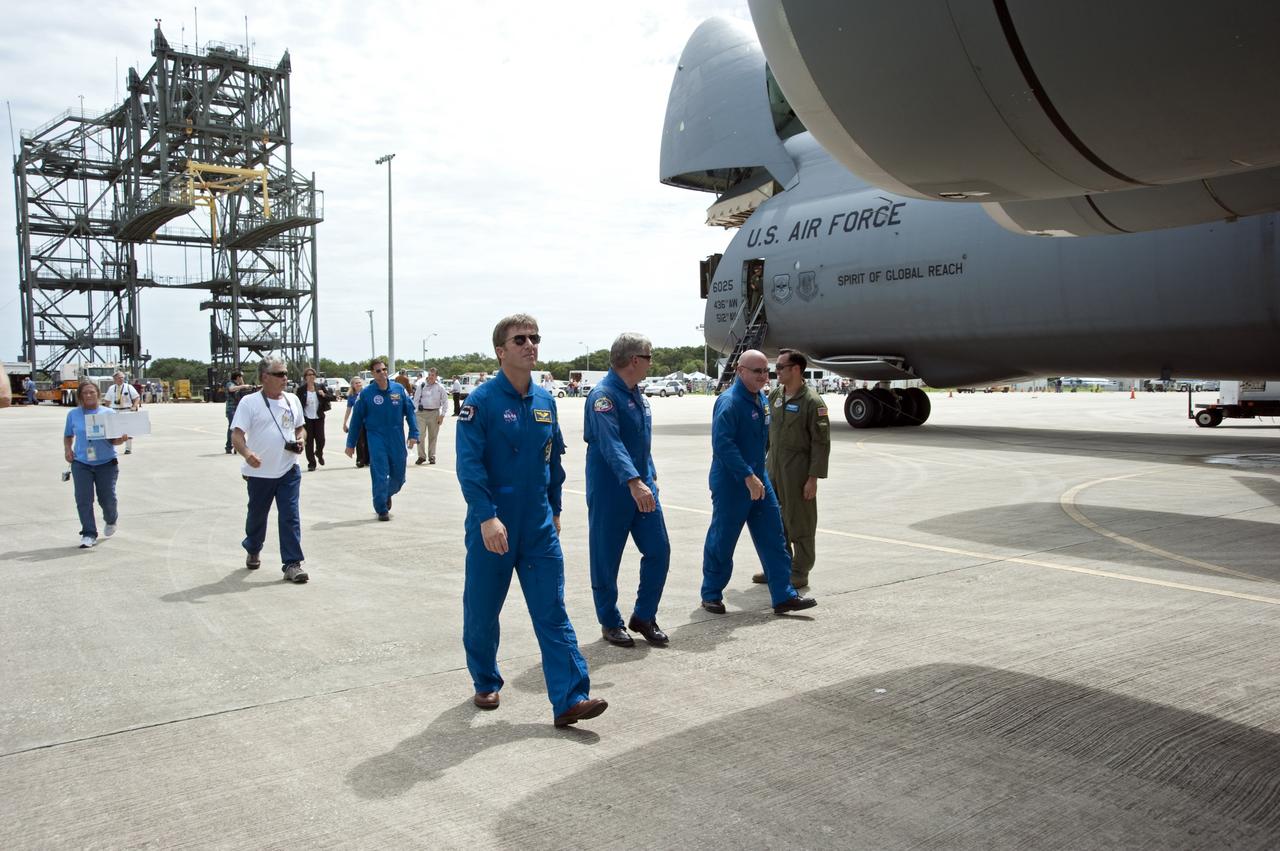 CAPE CANAVERAL, Fla. -- At the Shuttle Landing Facility at NASA's Kennedy Space Center in Florida, STS-134 European Space Agency astronaut Roberto Vittori is accompanied by Pilot Gregory H. Johnson and Commander Mark Kelly on the tarmac where the C-5M aircraft is parked after the arrival of the Alpha Magnetic Spectrometer, or AMS.          AMS, a state-of-the-art particle physics detector, is designed to operate as an external module on the International Space Station. It will use the unique environment of space to study the universe and its origin by searching for dark matter. AMS will fly to the International Space Station aboard space shuttle Endeavour's STS-134 mission targeted to launch Feb. 26, 2011. Photo credit: NASA/Kim Shiflett