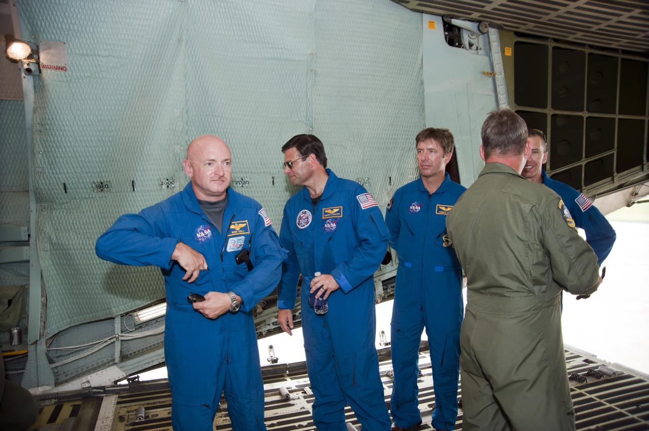 CAPE CANAVERAL, Fla. -- Inside the C-5M aircraft that delivered the Alpha Magnetic Spectrometer, or AMS, to the Shuttle Landing Facility at NASA's Kennedy Space Center in Florida, STS-134 Commander Mark Kelly, Mission Specialist Greg Chamitoff, European Space Agency astronaut Roberto Vittori and Mission Specialist Andrew Feustel speak with a member of the C-5M flight crew.          AMS, a state-of-the-art particle physics detector, is designed to operate as an external module on the International Space Station. It will use the unique environment of space to study the universe and its origin by searching for dark matter. AMS will fly to the International Space Station aboard space shuttle Endeavour's STS-134 mission targeted to launch Feb. 26, 2011. Photo credit: NASA/Kim Shiflett
