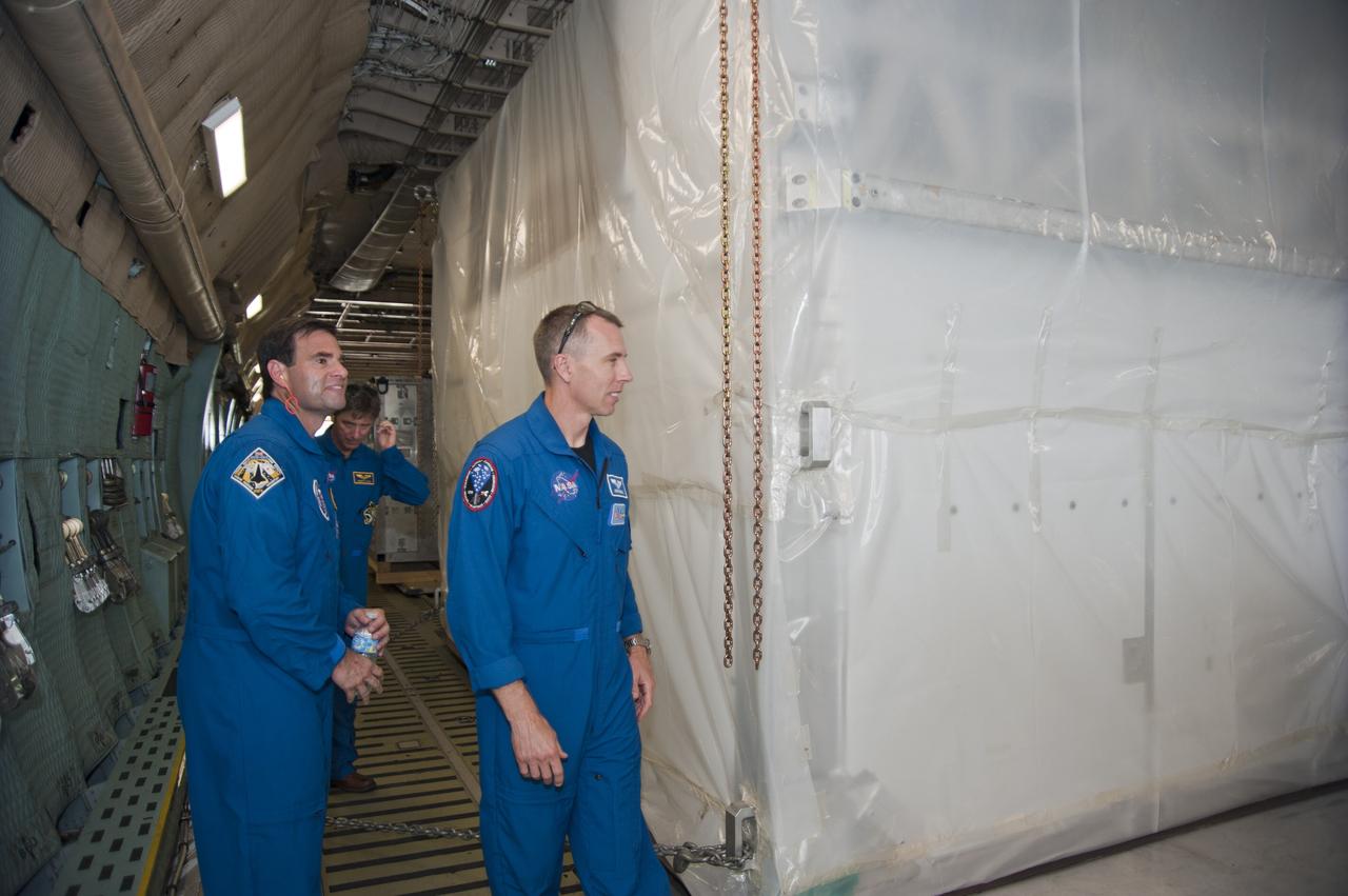 CAPE CANAVERAL, Fla. -- Inside the C-5M aircraft that delivered the Alpha Magnetic Spectrometer, or AMS, to the Shuttle Landing Facility at NASA's Kennedy Space Center in Florida, STS-134 Mission Specialists Greg Chamitoff and Andrew Feustel take a walk around the AMS still secured in the aircraft's cargo bay. In the background is European Space Agency astronaut Roberto Vittori.          AMS, a state-of-the-art particle physics detector, is designed to operate as an external module on the International Space Station. It will use the unique environment of space to study the universe and its origin by searching for dark matter. AMS will fly to the International Space Station aboard space shuttle Endeavour's STS-134 mission targeted to launch Feb. 26, 2011. Photo credit: NASA/Kim Shiflett