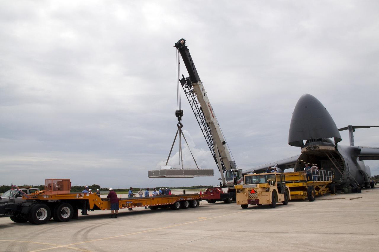 CAPE CANAVERAL, Fla. -- At NASA's Kennedy Space Center in Florida, a crane lowers a section of the Alpha Magnetic Spectrometer, or AMS, onto a tractor-trailer which will transport the AMS from the Shuttle Landing Facility runway to the Space Station Processing Facility, where it will be processed for launch.        AMS, a state-of-the-art particle physics detector, is designed to operate as an external module on the International Space Station. It will use the unique environment of space to study the universe and its origin by searching for dark matter. AMS will fly to the International Space Station aboard space shuttle Endeavour's STS-134 mission, targeted to launch Feb. 26, 2011. Photo credit: NASA/Jack Pfaller
