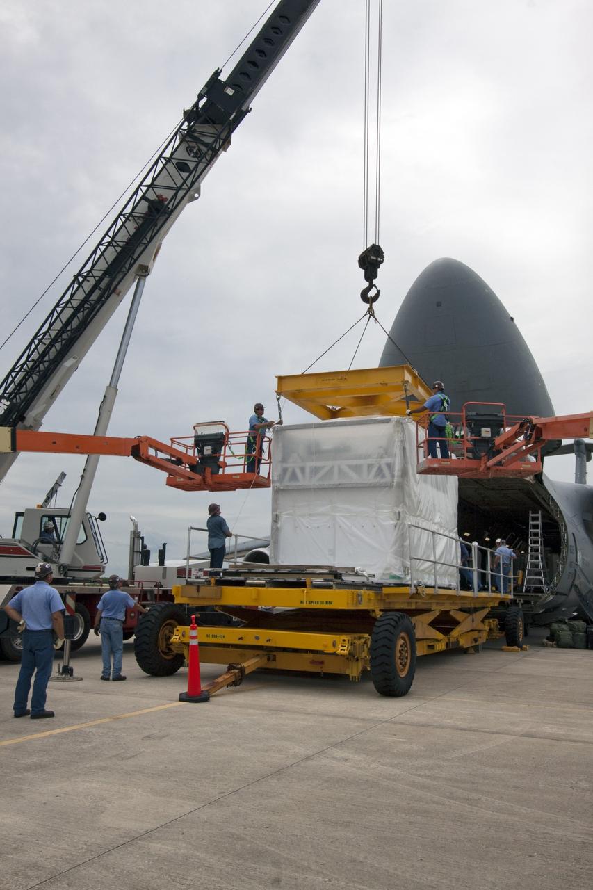 CAPE CANAVERAL, Fla. -- At NASA's Kennedy Space Center in Florida, workers begin to offload the next section of the  Alpha Magnetic Spectrometer, or AMS, from an Air Force C-5M aircraft. A tractor-trailer will transport the AMS from the Shuttle Landing Facility runway to the Space Station Processing Facility, where it will be processed for launch.         AMS, a state-of-the-art particle physics detector, is designed to operate as an external module on the International Space Station. It will use the unique environment of space to study the universe and its origin by searching for dark matter. AMS will fly to the International Space Station aboard space shuttle Endeavour's STS-134 mission, targeted to launch Feb. 26, 2011. Photo credit: NASA/Jack Pfaller