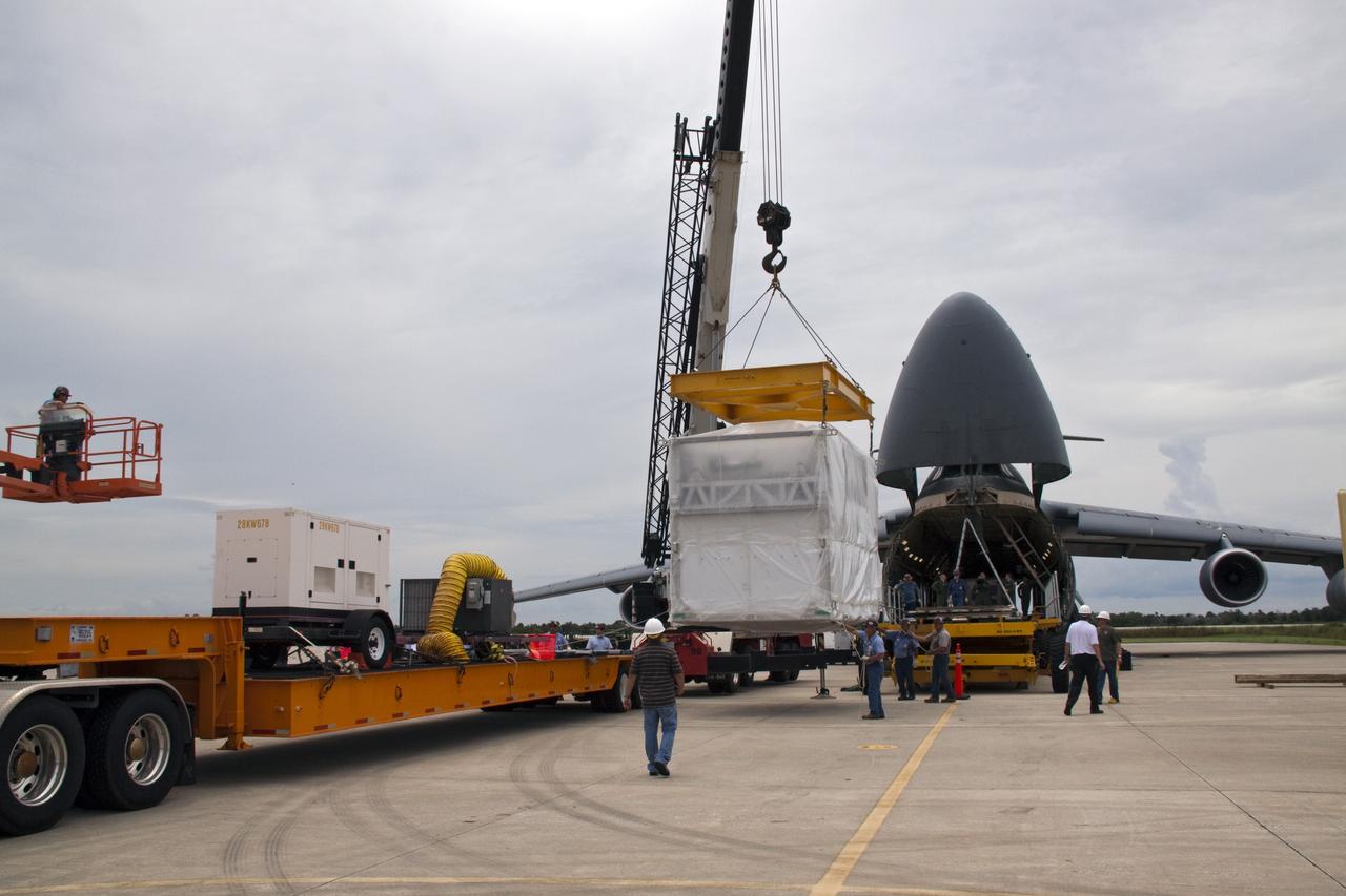 CAPE CANAVERAL, Fla. -- At NASA's Kennedy Space Center in Florida, a crane moves the next section of the Alpha Magnetic Spectrometer, or AMS, toward a tractor-trailer which will transport the AMS from the Shuttle Landing Facility runway to the Space Station Processing Facility, where it will be processed for launch.        AMS, a state-of-the-art particle physics detector, is designed to operate as an external module on the International Space Station. It will use the unique environment of space to study the universe and its origin by searching for dark matter. AMS will fly to the International Space Station aboard space shuttle Endeavour's STS-134 mission, targeted to launch Feb. 26, 2011. Photo credit: NASA/Jack Pfaller