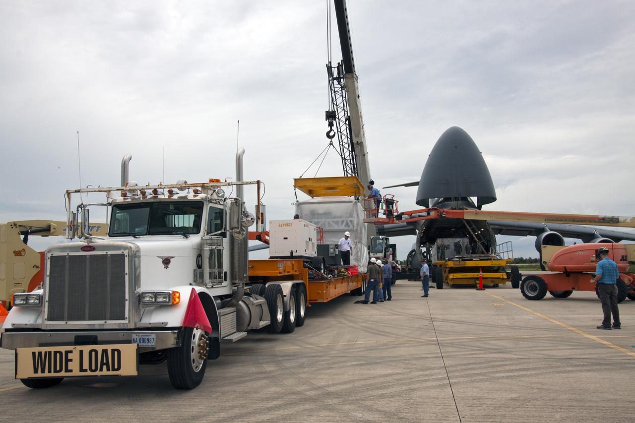 CAPE CANAVERAL, Fla. -- At NASA's Kennedy Space Center in Florida, a crane lowers the next section of the Alpha Magnetic Spectrometer, or AMS, onto a tractor-trailer which will transport the AMS from the Shuttle Landing Facility runway to the Space Station Processing Facility, where it will be processed for launch.        AMS, a state-of-the-art particle physics detector, is designed to operate as an external module on the International Space Station. It will use the unique environment of space to study the universe and its origin by searching for dark matter. AMS will fly to the International Space Station aboard space shuttle Endeavour's STS-134 mission, targeted to launch Feb. 26, 2011. Photo credit: NASA/Jack Pfaller