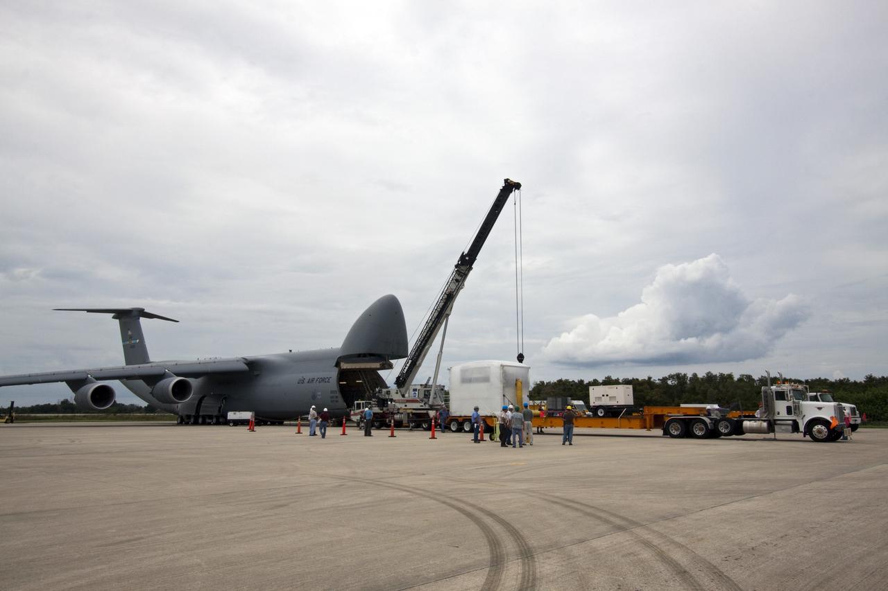 CAPE CANAVERAL, Fla. -- At NASA's Kennedy Space Center in Florida, workers begin to offload the Alpha Magnetic Spectrometer, or AMS, from an Air Force C-5M aircraft, which flew in from Europe. The tractor-trailer will transport the AMS from the Shuttle Landing Facility runway to the Space Station Processing Facility, where it will be processed for launch. The state-of-the-art particle physics detector is designed to operate as an external module on the International Space Station. It will use the unique environment of space to study the universe and its origin by searching for dark matter. AMS will fly to the station aboard space shuttle Endeavour's STS-134 mission targeted to launch Feb. 26, 2011. Photo credit: NASA/Jack Pfaller