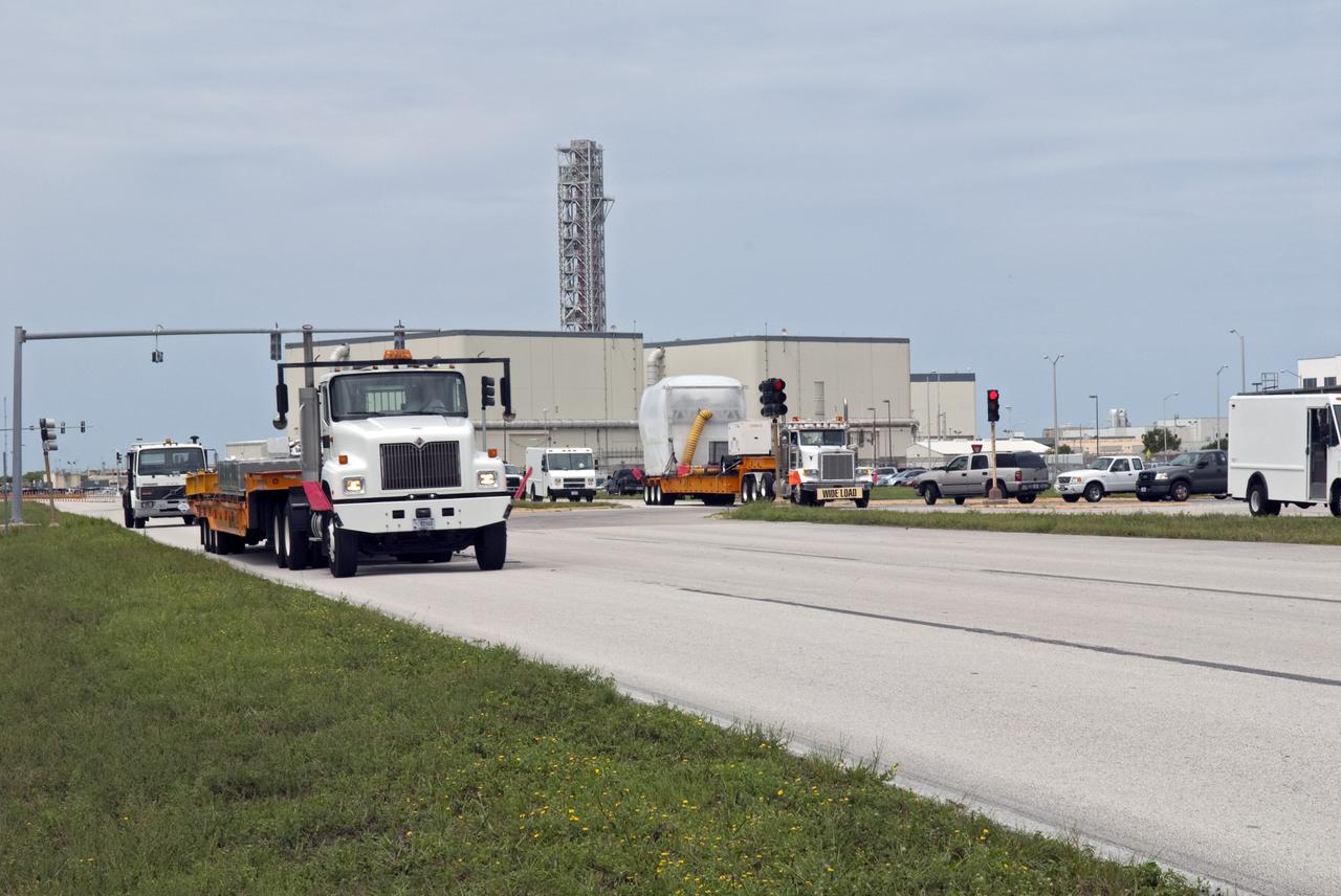 CAPE CANAVERAL, Fla. -- At NASA's Kennedy Space Center in Florida, a tractor-trailer carrying the Alpha Magnetic Spectrometer, or AMS, is on its way to the Space Station Processing Facility, where it will be processed for launch. AMS arrived on Kennedy's Shuttle Landing Facility aboard an Air Force C-5M aircraft from Europe.              AMS, a state-of-the-art particle physics detector, is designed to operate as an external module on the International Space Station. It will use the unique environment of space to study the universe and its origin by searching for dark matter. The STS-134 crew will fly AMS to the International Space Station aboard space shuttle Endeavour,   targeted to launch Feb. 26, 2011. Photo credit: NASA/Frankie Martin