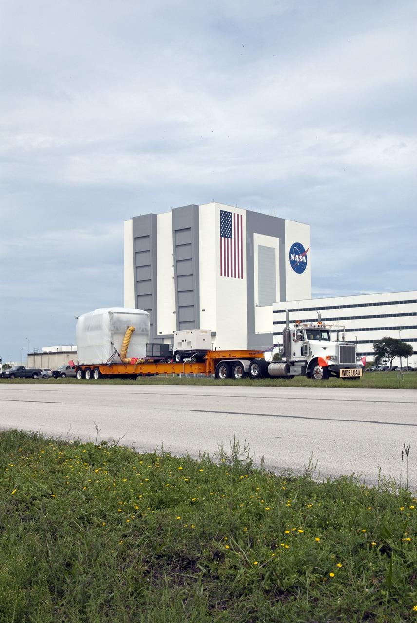 CAPE CANAVERAL, Fla. -- At NASA's Kennedy Space Center in Florida, a tractor-trailer carrying the Alpha Magnetic Spectrometer, or AMS, passes the Vehicle Assembly Building en route to the Space Station Processing Facility. The state-of-the-art particle physics detector arrived on Kennedy's Shuttle Landing Facility aboard an Air Force C-5M aircraft from Europe. It will operate as an external module on the International Space Station to study the universe and its origin by searching for dark matter. AMS will fly to the station aboard space shuttle Endeavour's STS-134 mission targeted to launch Feb. 26, 2011. Photo credit: NASA/Frankie Martin