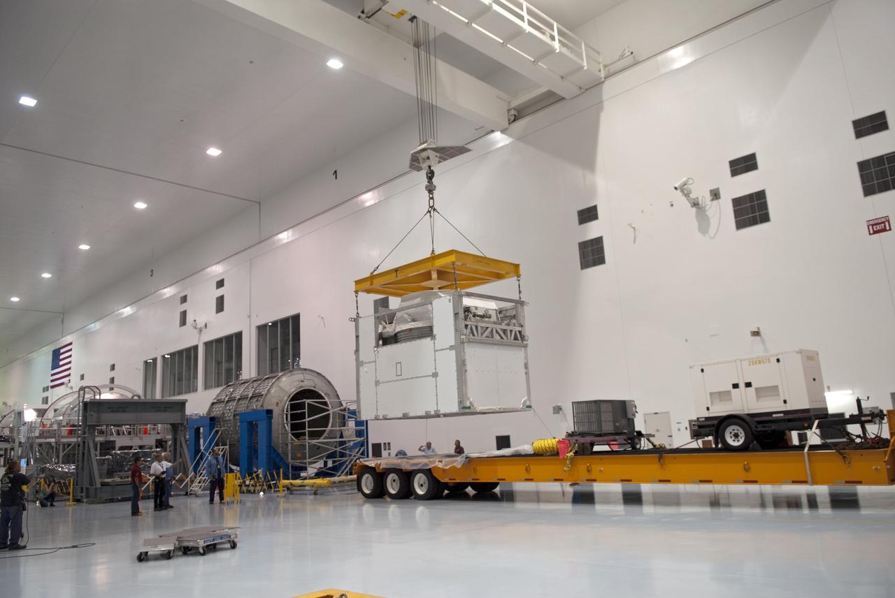 CAPE CANAVERAL, Fla. -- In the Space Station Processing Facility at NASA's Kennedy Space Center in Florida an overhead crane lifts the Alpha Magnetic Spectrometer, or AMS, off of the tractor-trailer that delivered it.         AMS, a state-of-the-art particle physics detector, is designed to operate as an external module on the International Space Station. It will use the unique environment of space to study the universe and its origin by searching for dark matter. The STS-134 crew will fly AMS to the International Space Station aboard space shuttle Endeavour,   targeted to launch Feb. 26, 2011. Photo credit: NASA/Frankie Martin