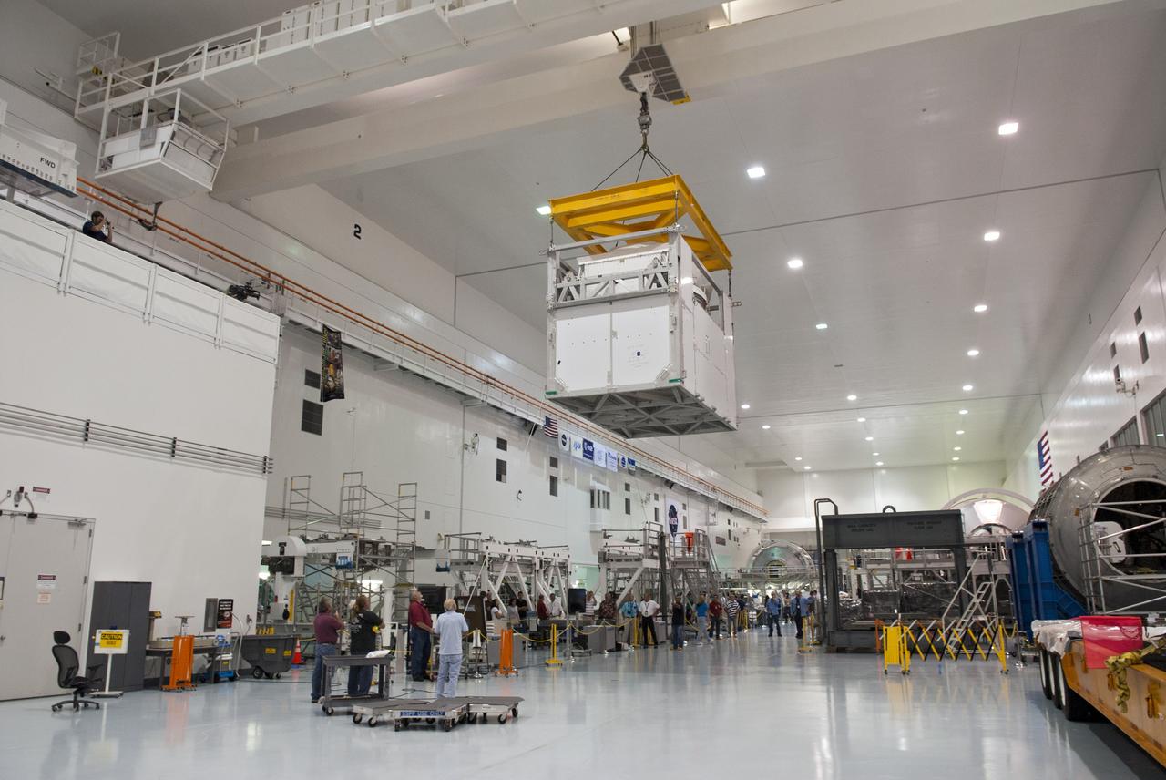 CAPE CANAVERAL, Fla. -- Workers in the Space Station Processing Facility at NASA's Kennedy Space Center in Florida, monitor the progress of an overhead crane as it moves the Alpha Magnetic Spectrometer, or AMS, to an area for technicians to prepare it for launch.        AMS, a state-of-the-art particle physics detector, is designed to operate as an external module on the International Space Station. It will use the unique environment of space to study the universe and its origin by searching for dark matter. The STS-134 crew will fly AMS to the International Space Station aboard space shuttle Endeavour,   targeted to launch Feb. 26, 2011. Photo credit: NASA/Frankie Martin