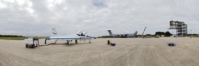 CAPE CANAVERAL, Fla. -- At NASA's Kennedy Space Center in Florida, media and workers watch as the Alpha Magnetic Spectrometer (AMS) is offloaded from an Air Force C-5M aircraft on the Shuttle Landing Facility runway. One of NASA's T-38 training jets, flown by a member of the STS-134 crew, is in the foreground. The state-of-the-art particle physics detector arrived from Europe and will operate as an external module on the International Space Station to study the universe and its origin by searching for dark matter.      AMS will fly to the station aboard space shuttle Endeavour's STS-134 mission targeted to launch Feb. 26, 2011.  Photo credit: NASA/Frankie Martin