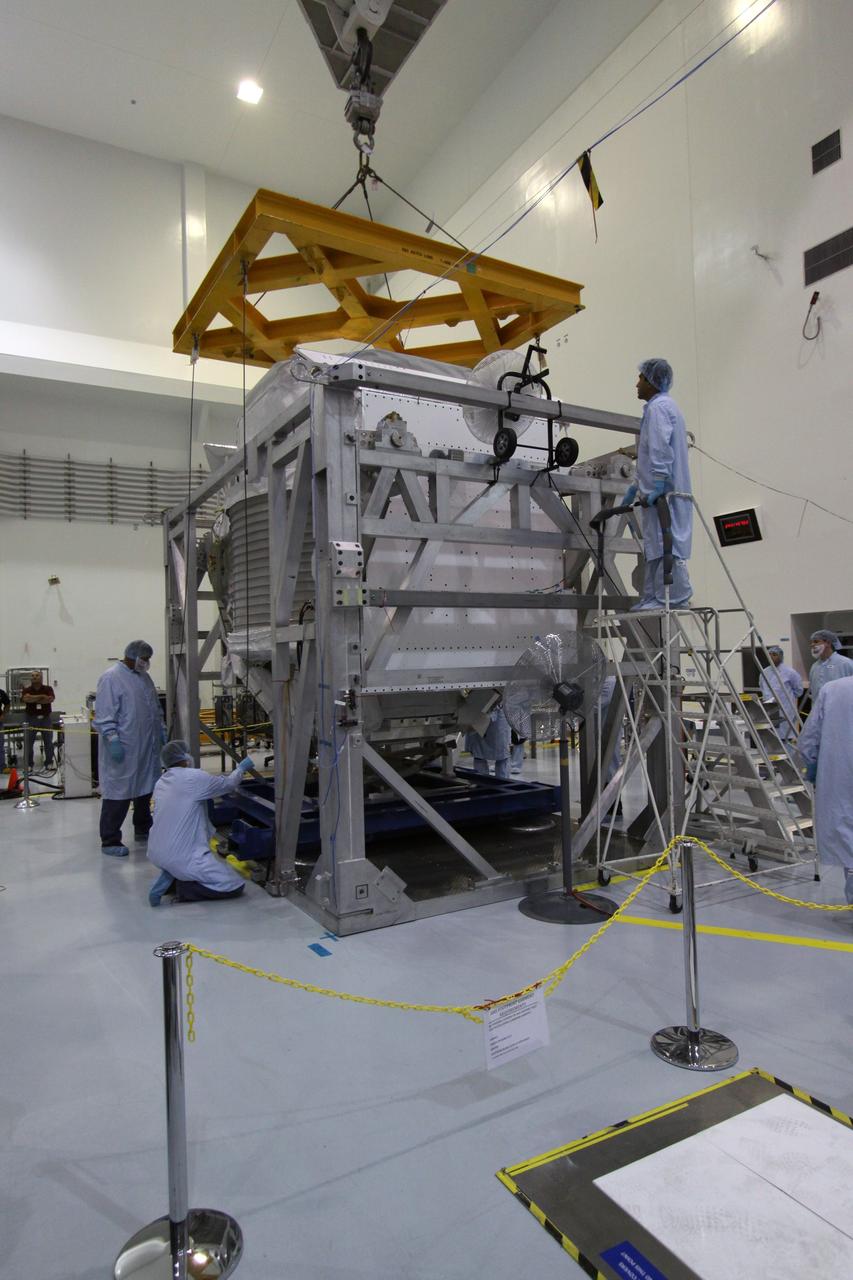 CAPE CANAVERAL, Fla. -- Technicians in the Space Station Processing Facility at NASA's Kennedy Space Center in Florida, monitor the guide wires of the overhead crane as it lifts the Payload Attach System, or PAS, up to the Alpha Magnetic Spectrometer, or AMS, for installation. The PAS provides a method of securely connecting the payload to the International Space Station.      AMS, a state-of-the-art particle physics detector, is designed to operate as an external module on the International Space Station. It will use the unique environment of space to study the universe and its origin by searching for dark matter. AMS will fly to the station aboard space shuttle Endeavour's STS-134 mission targeted to launch Feb. 26, 2011. Photo credit: NASA/Jack Pfaller