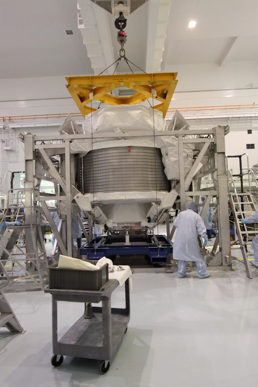 CAPE CANAVERAL, Fla. -- A technicians in the Space Station Processing Facility at NASA's Kennedy Space Center in Florida, check the progress of the Payload Attach System, or PAS, as it is lifted up to the Alpha Magnetic Spectrometer, or AMS, where it will be attached to the bottom of the AMS. The PAS provides a method of securely connecting the payload to the International Space Station.      AMS, a state-of-the-art particle physics detector, is designed to operate as an external module on the International Space Station. It will use the unique environment of space to study the universe and its origin by searching for dark matter. AMS will fly to the station aboard space shuttle Endeavour's STS-134 mission targeted to launch Feb. 26, 2011. Photo credit: NASA/Jack Pfaller