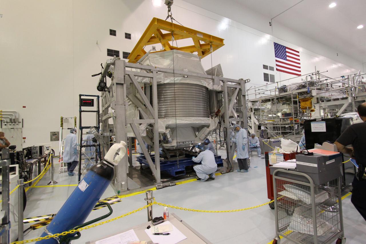 CAPE CANAVERAL, Fla. -- Technicians in the Space Station Processing Facility at NASA's Kennedy Space Center in Florida, check the progress of the Payload Attach System, or PAS, as it is lifted up to the Alpha Magnetic Spectrometer, where it will be attached to the bottom of the AMS. The PAS provides a method of securely connecting the payload to the International Space Station.      AMS, a state-of-the-art particle physics detector, is designed to operate as an external module on the International Space Station. It will use the unique environment of space to study the universe and its origin by searching for dark matter. AMS will fly to the station aboard space shuttle Endeavour's STS-134 mission targeted to launch Feb. 26, 2011. Photo credit: NASA/Jack Pfaller