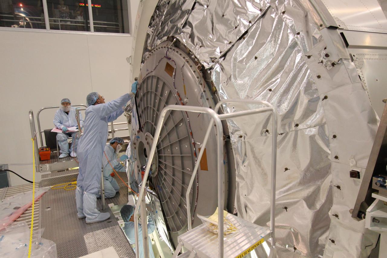 CAPE CANAVERAL, Fla. -- In the Space Station Processing Facility at NASA's Kennedy Space Center in Florida, technicians install insulating blankets to the hatch of the Permanent Multipurpose Module, or PMM, to protect it and its contents from the harsh environment and temperatures of space. Space shuttle Discovery and its STS-133 crew are targeted to launch Nov. 1 and will deliver the PMM, packed with supplies and critical spare parts, as well as Robonaut 2, the dexterous humanoid astronaut helper, to the International Space Station. For more information visit: www.nasa.gov/shuttle. Photo credit: NASA/Jack Pfaller