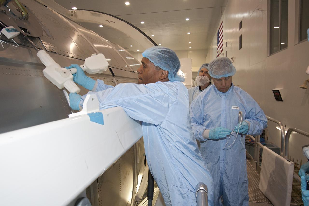 CAPE CANAVERAL, Fla. -- In the Space Station Processing Facility at NASA's Kennedy Space Center in Florida, STS-133 Mission Specialist Alvin Drew practices with a tool on the Permanent Multipurpose Module, or PMM, while Mission Specialist Tim Kopra (right) awaits his turn.         The astronauts are at Kennedy to participate in the Payload Crew Equipment Interface Test, or CEIT, which gives  the crew an opportunity for hands-on training with tools they'll be using in space and familiarization of the payload they will be delivering to the International Space Station. Launch of space shuttle Discovery is targeted for Nov. 1 at 4:40 p.m. EDT. For more information visit, www.nasa.gov/shuttle. Photo credit: NASA/Jack Pfaller