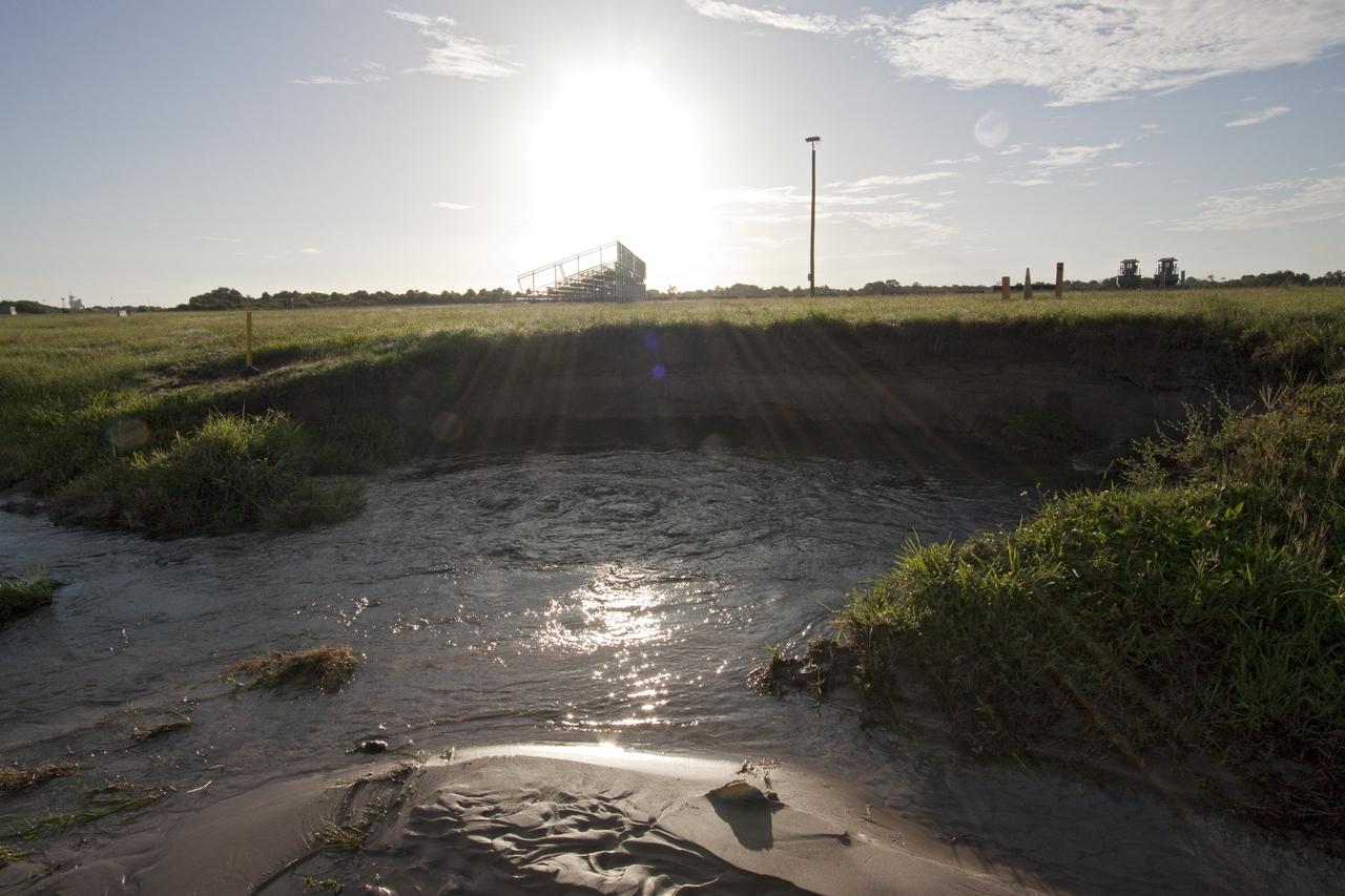 CAPE CANAVERAL, Fla. -- Looking towards a shuttle launch viewing stand is the result of a major water main leak in a 24-inch pipe that caused soil to wash away near the Press Site in the LC-39 Complex Turn Basin area across from the Vehicle Assembly Building at NASA's Kennedy Space Center in Florida. The center was closed for the morning while workers assessed and repaired the break. Photo credit: NASA/Jack Pfaller