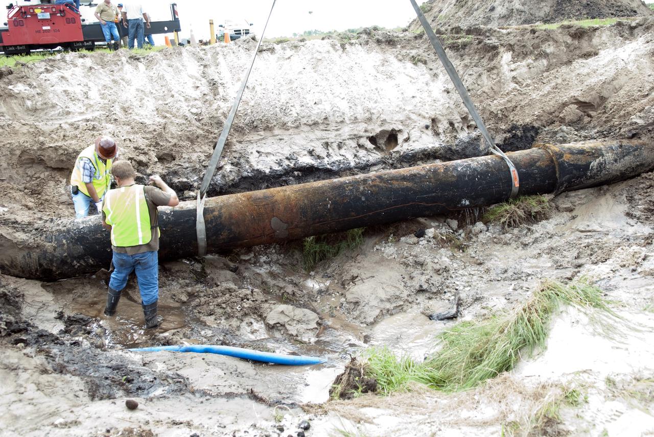 CAPE CANAVERAL, Fla. -- At NASA's Kennedy Space Center in Florida, a crew begins to fix a major water main break in a 24-inch cast iron pipe in the Launch Complex-39 Turn Basin area, across from the Vehicle Assembly Building and the Launch Control Center. This photo shows the approximately 15-foot-long crack along the bottom of pipe and water draining out. Kennedy was closed to non-essential personnel the morning of Sept. 8 while crews assessed the break and restored water to the center.    Photo credit: NASA/Jim Grossmann