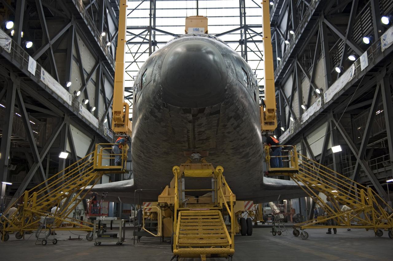 CAPE CANAVERAL, Fla. -- At NASA's Kennedy Space Center in Florida, workers in the Vehicle Assembly Building begin to secure a large yellow, metal sling to shuttle Discovery for its lift from the transfer aisle into High Bay 3. In the bay, the shuttle will be attached to its external fuel tank and solid rocket boosters. The operation began Sept. 9 and wrapped up early Sept. 10. Discovery is scheduled to roll out to Launch Pad 39A later this month in preparation for its launch to the International Space Station on the STS-133 mission. Targeted to lift off Nov. 1, Discovery will take the Permanent Multipurpose Module (PMM) packed with supplies and critical spare parts, as well as Robonaut 2 (R2) to the station. Photo credit: NASA/Kim Shiflett