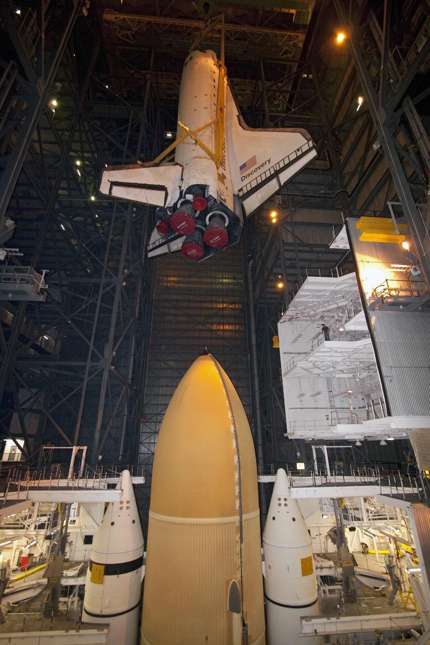 CAPE CANAVERAL, Fla. -- In High Bay 3 of the Vehicle Assembly Building at NASA's Kennedy Space Center in Florida, a large yellow, metal sling lowers shuttle Discovery to its external fuel tank and solid rocket boosters. The lift and mate operation began Sept. 9 and wrapped up early Sept. 10. Discovery is scheduled to roll out to Launch Pad 39A later this month in preparation for its launch to the International Space Station on the STS-133 mission. Targeted to lift off Nov. 1, Discovery will take the Permanent Multipurpose Module (PMM) packed with supplies and critical spare parts, as well as Robonaut 2 (R2) to the station. Photo credit: NASA/Jack Pfaller