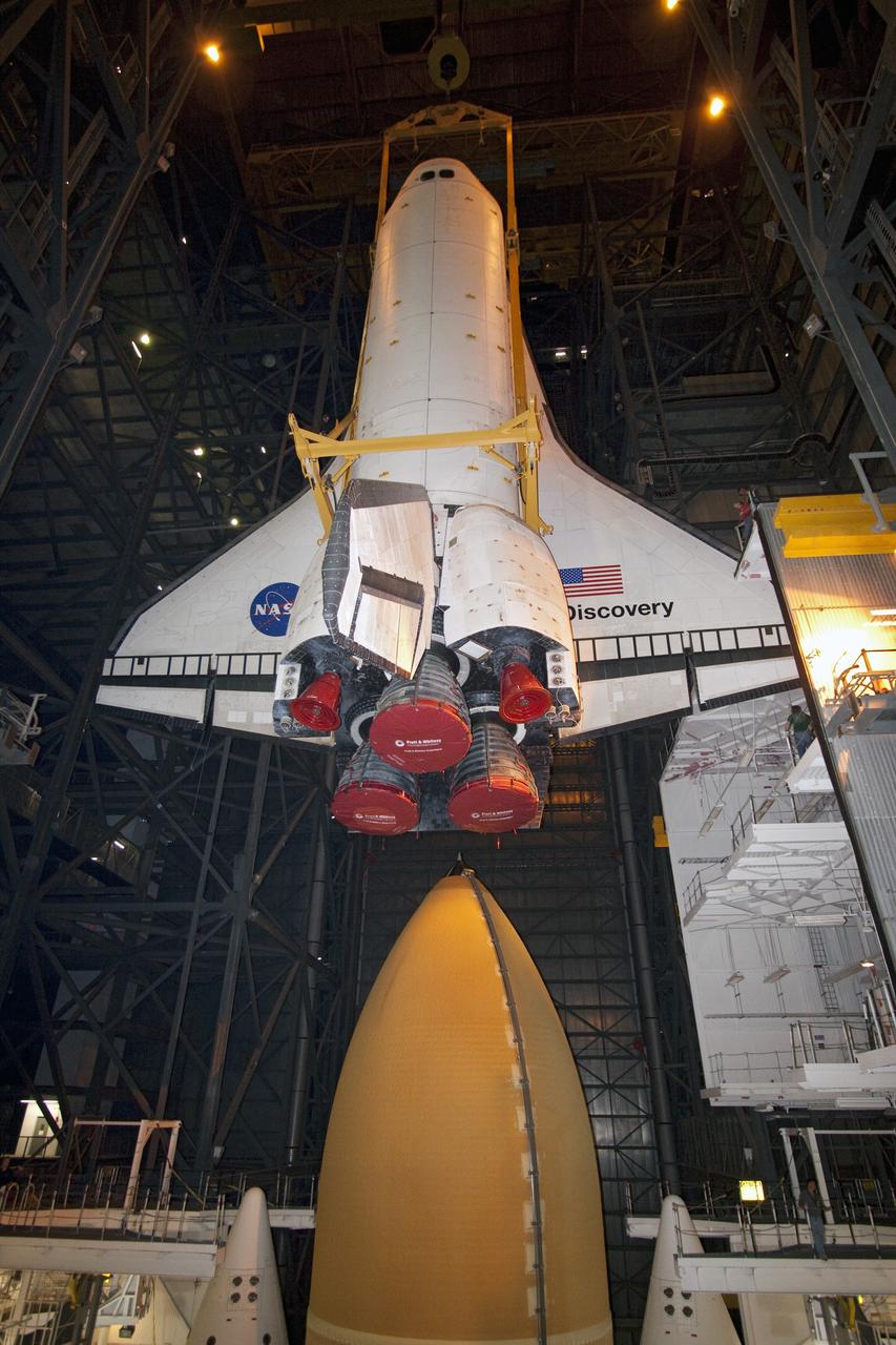 CAPE CANAVERAL, Fla. -- In High Bay 3 of the Vehicle Assembly Building at NASA's Kennedy Space Center in Florida, a large yellow, metal sling lowers shuttle Discovery to its external fuel tank and solid rocket boosters. The lift and mate operation began Sept. 9 and wrapped up early Sept. 10. Discovery is scheduled to roll out to Launch Pad 39A later this month in preparation for its launch to the International Space Station on the STS-133 mission. Targeted to lift off Nov. 1, Discovery will take the Permanent Multipurpose Module (PMM) packed with supplies and critical spare parts, as well as Robonaut 2 (R2) to the station. Photo credit: NASA/Jack Pfaller