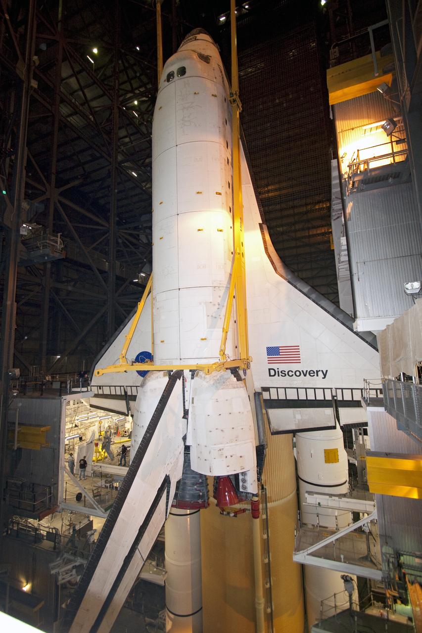 CAPE CANAVERAL, Fla. -- In High Bay 3 of the Vehicle Assembly Building at NASA's Kennedy Space Center in Florida, a large yellow, metal sling lowers shuttle Discovery to its external fuel tank and solid rocket boosters. The lift and mate operation began Sept. 9 and wrapped up early Sept. 10. Discovery is scheduled to roll out to Launch Pad 39A later this month in preparation for its launch to the International Space Station on the STS-133 mission. Targeted to lift off Nov. 1, Discovery will take the Permanent Multipurpose Module (PMM) packed with supplies and critical spare parts, as well as Robonaut 2 (R2) to the station. Photo credit: NASA/Jack Pfaller