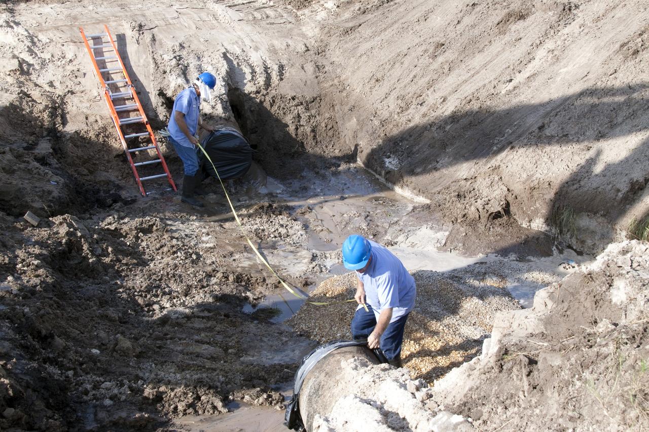 CAPE CANAVERAL, Fla. -- In the Launch Complex-39 Turn Basin area, across from the Vehicle Assembly Building at NASA's Kennedy Space Center in Florida, workers take measurements for replacement sections of a 24-inch cast iron water main pipe. Kennedy was closed to non-essential personnel the morning of Sept. 8 while crews assessed the water main break and restored water to the center. Photo credit: NASA/Jack Pfaller