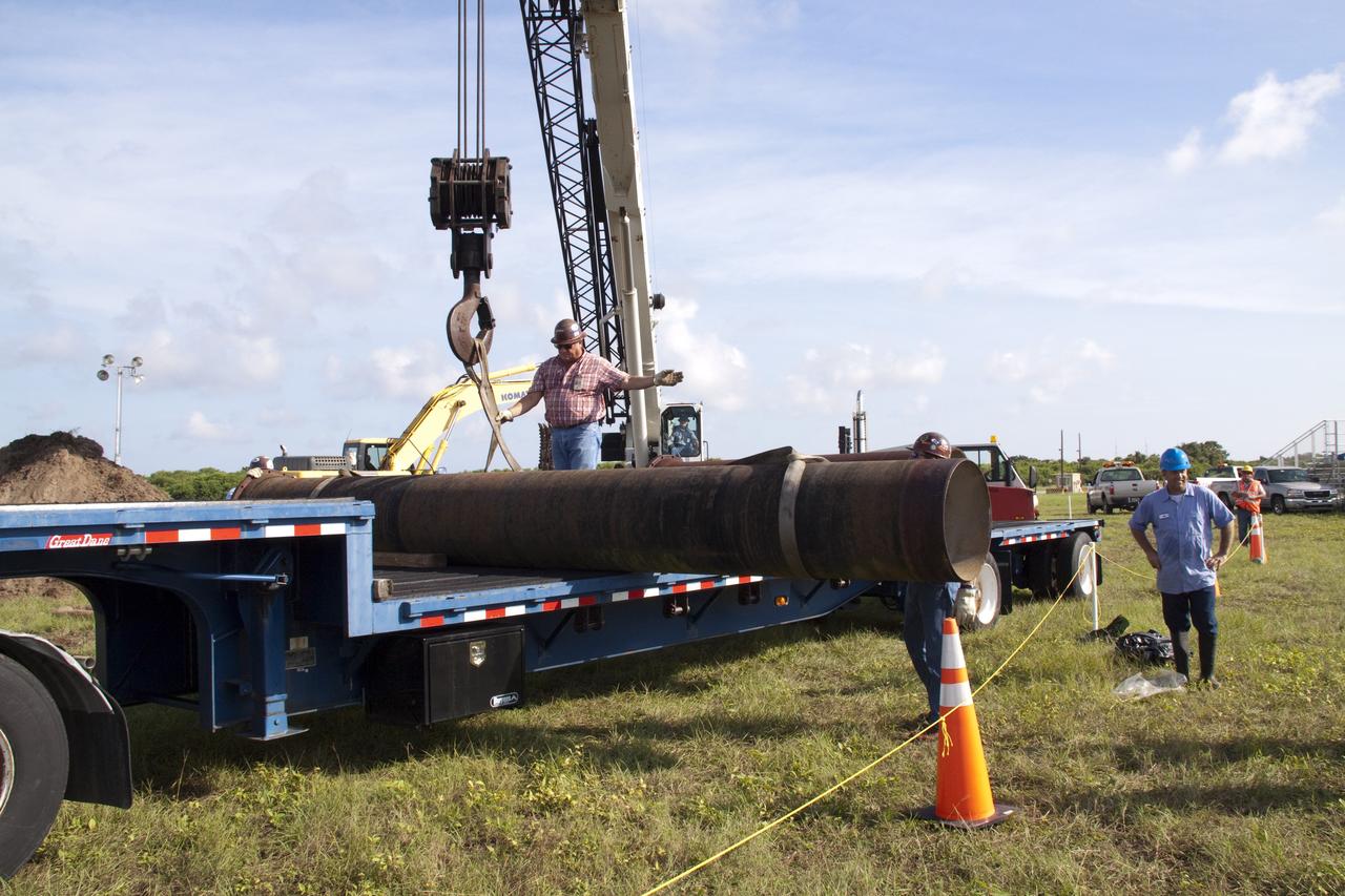 CAPE CANAVERAL, Fla. -- In the Launch Complex-39 Turn Basin area, across from the Vehicle Assembly Building at NASA's Kennedy Space Center in Florida, workers maneuver the replacement sections of a 24-inch cast iron water main pipe off of a transport truck. Kennedy was closed to non-essential personnel the morning of Sept. 8 while crews assessed the water main break and restored water to the center. Photo credit: NASA/Jack Pfaller