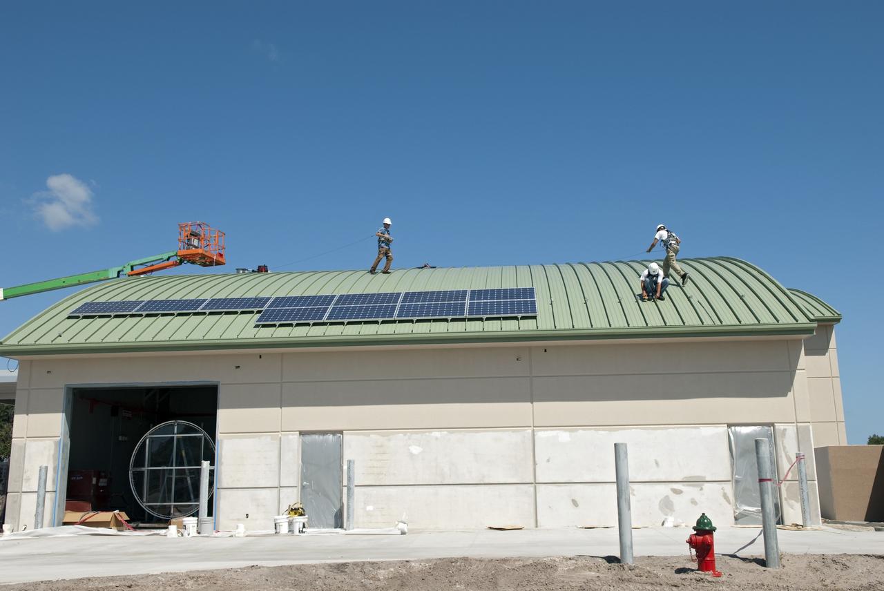 CAPE CANAVERAL, Fla. - Workers of Superior Solar LLC in Longwood, Fla., begin to install more than 300 solar panels on the roof of the Propellants North Administrative and Maintenance Facility at NASA's Kennedy Space Center in Florida. Each panel, built in Sharp Corp.'s Memphis, Tenn., plant, will produce 235 watts of clean energy. The green facility in Kennedy's Launch Complex 39 area will have a two-story administrative building to house managers, mechanics and technicians who fuel spacecraft at Kennedy adjacent to a single-story shop to store cryogenic fuel transfer equipment.     The facility is striving to qualify for the U.S. Green Building Council’s Leadership in Energy and Environmental Design (LEED) Platinum certification. If successful, it will be the first NASA facility to achieve this highest of LEED ratings after it is completed. The facility was designed for NASA by Jones Edmunds and Associates. H. W. Davis Construction is the construction contractor. Photo credit: NASA/Jim Grossmann