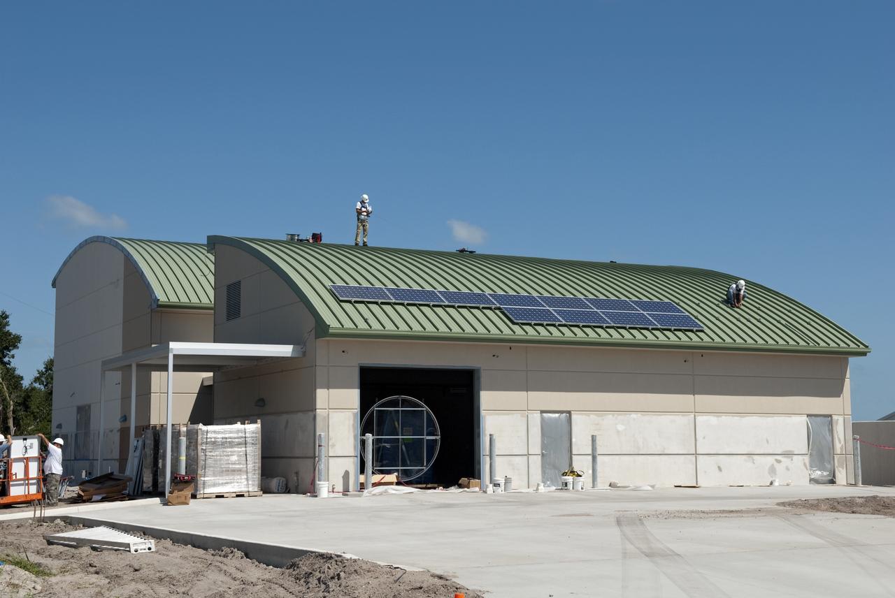 CAPE CANAVERAL, Fla. - Workers of Superior Solar LLC in Longwood, Fla., begin to install more than 300 solar panels on the roof of the Propellants North Administrative and Maintenance Facility at NASA's Kennedy Space Center in Florida. Each panel, built in Sharp Corp.'s Memphis, Tenn., plant, will produce 235 watts of clean energy. The green facility in Kennedy's Launch Complex 39 area will have a two-story administrative building to house managers, mechanics and technicians who fuel spacecraft at Kennedy adjacent to a single-story shop to store cryogenic fuel transfer equipment.     The facility is striving to qualify for the U.S. Green Building Council’s Leadership in Energy and Environmental Design (LEED) Platinum certification. If successful, it will be the first NASA facility to achieve this highest of LEED ratings after it is completed. The facility was designed for NASA by Jones Edmunds and Associates. H. W. Davis Construction is the construction contractor. Photo credit: NASA/Jim Grossmann