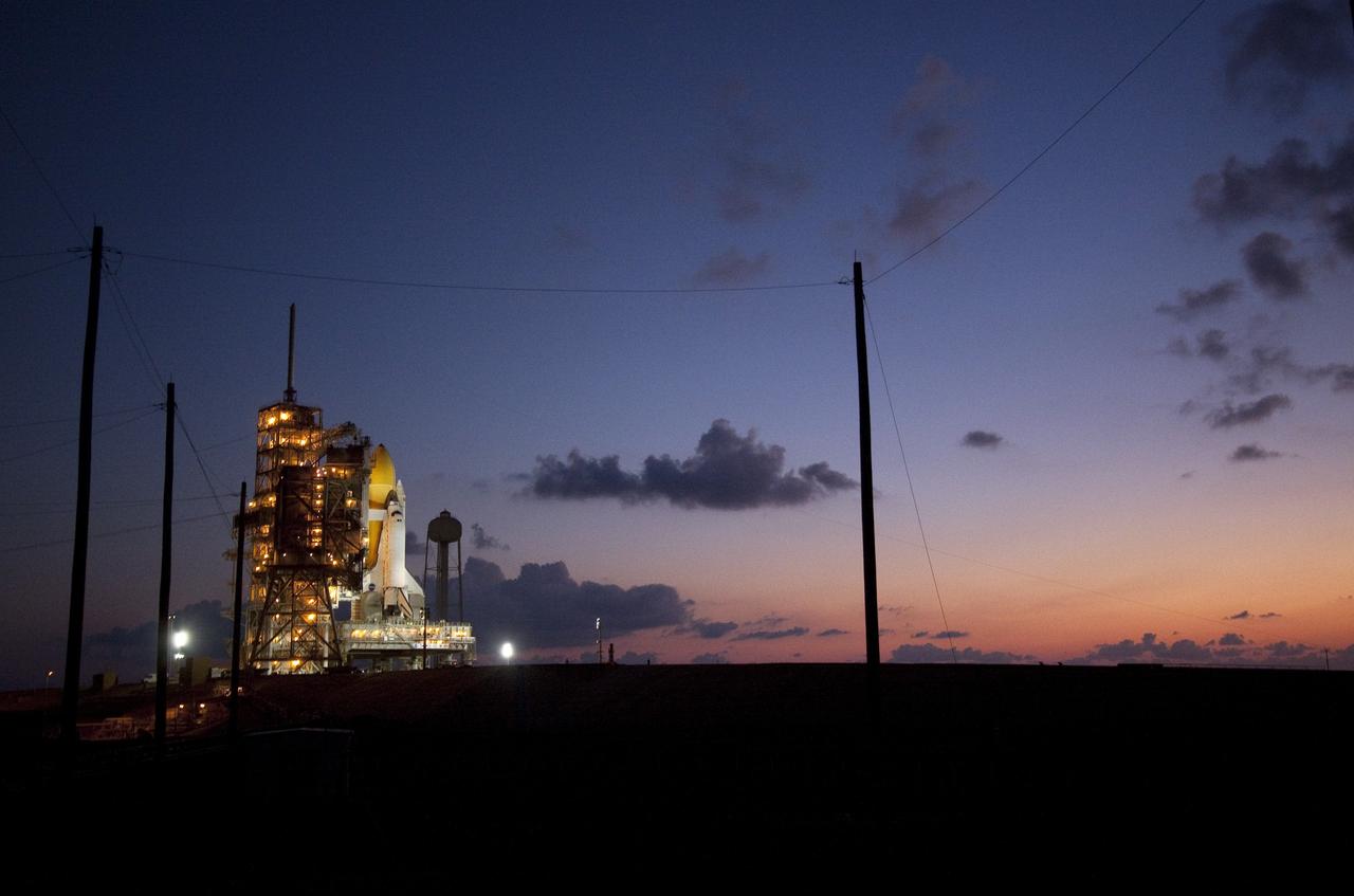 CAPE CANAVERAL, Fla. -- Space shuttle Discovery is attached to Launch Pad 39A as the sun rises over NASA's Kennedy Space Center in Florida. It took the spacecraft about six hours to make the journey, known as "rollout," from the Vehicle Assembly Building to the pad. Rollout sets the stage for Discovery's STS-133 crew to practice countdown and launch procedures during the Terminal Countdown Demonstration Test in mid-October. Targeted to liftoff Nov. 1, Discovery will take the Permanent Multipurpose Module (PMM) packed with supplies and critical spare parts, as well as Robonaut 2 (R2) to the International Space Station. Photo credit: NASA/Jack Pfaller