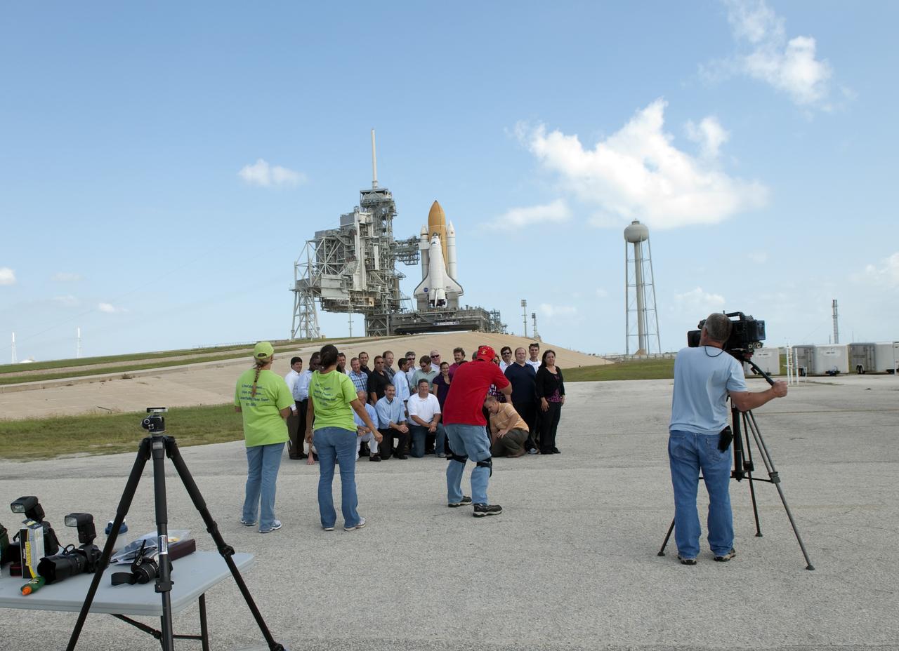 CAPE CANAVERAL, Fla. -- At NASA's Kennedy Space Center in Florida, space center workers pose for a group photo in front of space shuttle Discovery, which is visible on Launch Pad 39A. Later, the rotating service structure that protects the shuttle from the elements will be moved into place. It took the spacecraft about six hours to make the journey, known as "rollout," from the Vehicle Assembly Building to the pad. Rollout sets the stage for Discovery's STS-133 crew to practice countdown and launch procedures during the Terminal Countdown Demonstration Test in mid-October. Targeted to liftoff Nov. 1, Discovery will take the Permanent Multipurpose Module (PMM) packed with supplies and critical spare parts, as well as Robonaut 2 (R2) to the International Space Station. Photo credit: NASA/Jim Grossmann