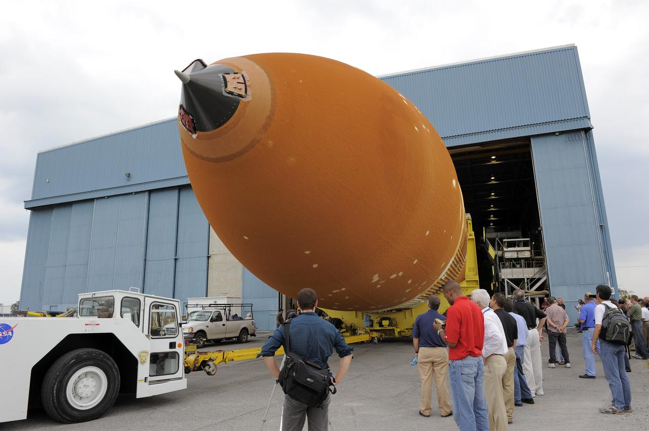 NEW ORLEANS -- Workers watch as the Space Shuttle Program's last external fuel tank, ET-122, rolls out of its processing hangar at NASA's Michoud Assembly Facility in New Orleans. The tank will travel 900 miles aboard the Pegasus Barge to NASA's Kennedy Space Center in Florida where it will be integrated to space shuttle Endeavour for the STS-134 mission to the International Space Station. STS-134, targeted to launch in 2011, currently is scheduled to be the last mission in the Space Shuttle Program.    The tank, which is the largest element of the space shuttle stack, was damaged during Hurricane Katrina in August 2005 and restored to flight configuration by Lockheed Martin Space Systems Company employees. Photo credit: NASA/Kim Shiflett