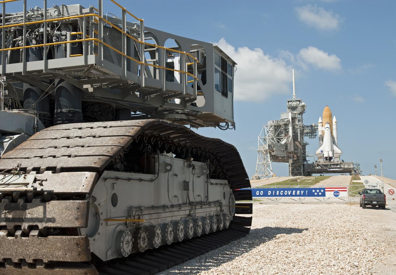 CAPE CANAVERAL, Fla. -- At NASA's Kennedy Space Center in Florida, the crawler-transporter that carried space shuttle Discovery from the Vehicle Assembly Building to Launch Pad 39A, moves toward the pad perimeter gate, giving the illusion that the shuttle is still on top, but smaller than it actually is. The move, called "rollout," sets the stage for Discovery's STS-133 crew to practice countdown and launch procedures during the Terminal Countdown Demonstration Test in mid-October. Targeted to liftoff Nov. 1, Discovery will take the Permanent Multipurpose Module (PMM) packed with supplies and critical spare parts, as well as Robonaut 2 (R2) to the International Space Station. Photo credit: NASA/Jim Grossmann