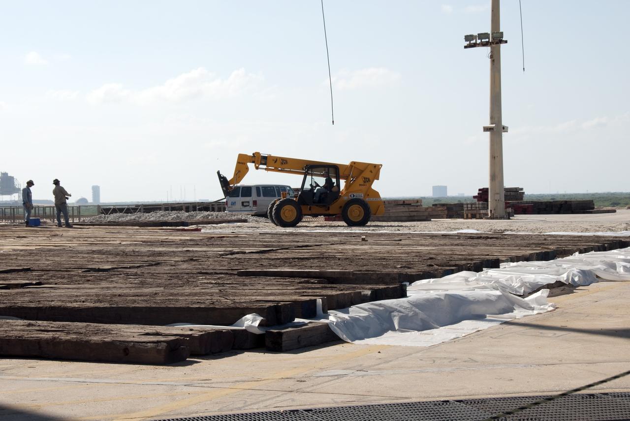CAPE CANAVERAL, Fla. -- At NASA's Kennedy Space Center in Florida, construction crews lay large wooden mats on top of sand and reinforcing steel to protect the concrete under the rotating service structure (RSS) of Launch Pad 39B during deconstruction.    Starting in 2009, the structure at Pad B was no longer needed for NASA's Space Shuttle Program, so it is being restructured for future use. The new design will feature a "clean pad" for rockets to come with their own launcher, making it more versatile for a number of vehicles. For information on NASA's future plans, visit www.nasa.gov. Photo credit: NASA/Jim Grossmann