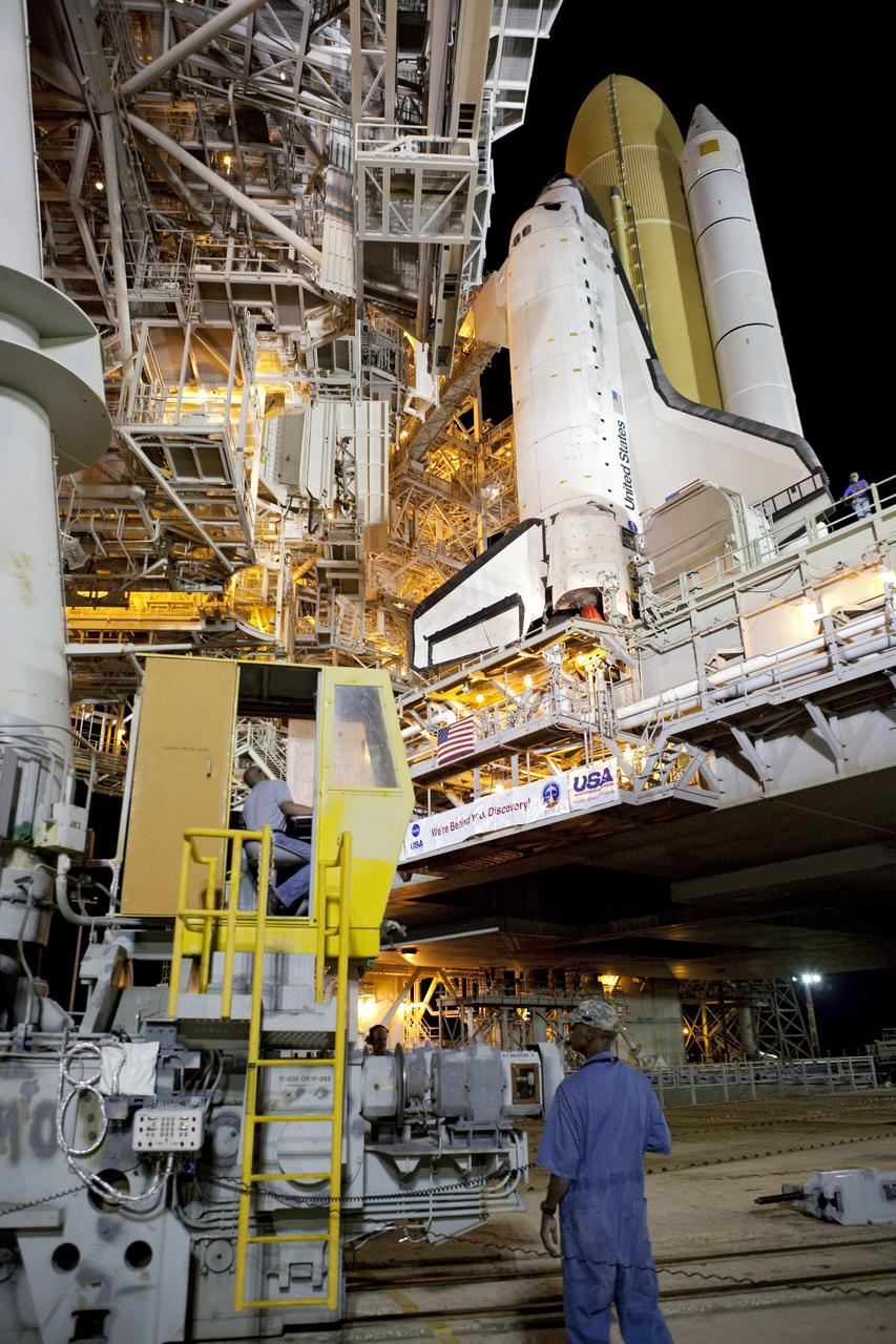 CAPE CANAVERAL, Fla. -- Workers at NASA's Kennedy Space Center in Florida move the rotating service structure into place around space shuttle Discovery on Launch Pad 39A. The structure protects the shuttle from the elements and allows access into the spacecraft while on the pad. Targeted to liftoff Nov. 1, Discovery will take the Permanent Multipurpose Module (PMM) packed with supplies and critical spare parts, as well as Robonaut 2 (R2) to the International Space Station on the STS-133 mission. Photo credit: NASA/Dimitri Gerondidakis