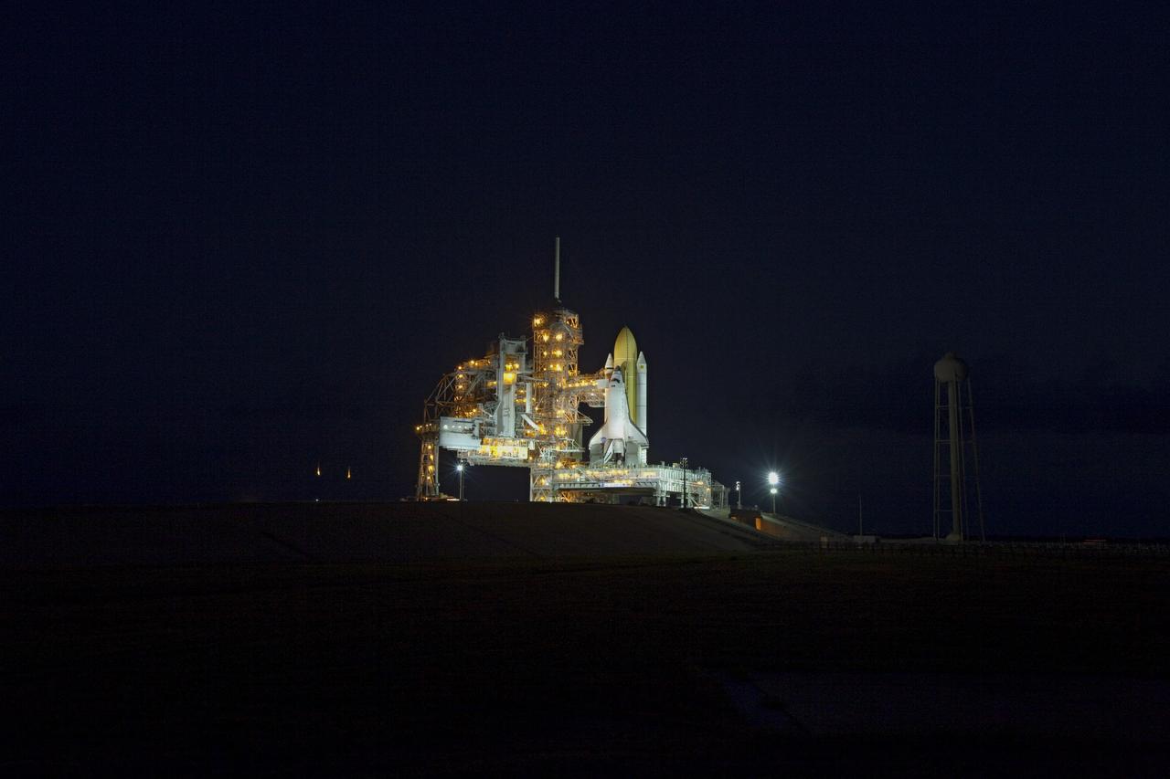 CAPE CANAVERAL, Fla. -- Just after sunset, space shuttle Discovery is attached to Launch Pad 39A at NASA's Kennedy Space Center in Florida. Meanwhile, workers prepare to move the rotating service structure, which protects the shuttle from the elements and provides access inside, into place. It took the spacecraft about six hours to make the journey, known as "rollout," from the Vehicle Assembly Building to the pad. Rollout sets the stage for Discovery's STS-133 crew to practice countdown and launch procedures during the Terminal Countdown Demonstration Test in mid-October. Targeted to liftoff Nov. 1, Discovery will take the Permanent Multipurpose Module (PMM) packed with supplies and critical spare parts, as well as Robonaut 2 (R2) to the International Space Station. Photo credit: NASA/Frankie Martin