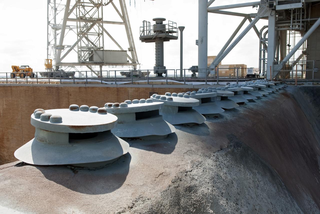 CAPE CANAVERAL, Fla. -- At NASA's Kennedy Space Center in Florida, caps from the fuel tanks that serviced the shuttle's external fuel tank are seen in this image above the flame trench during deconstruction of Launch Pad 39B.          Starting in 2009, the structure at Pad B was no longer needed for NASA's Space Shuttle Program, so it is being restructured for future use. The new design will feature a "clean pad" for rockets to come with their own launcher, making it more versatile for a number of vehicles. For information on NASA's future plans, visit www.nasa.gov. Photo credit: NASA/Jim Grossmann