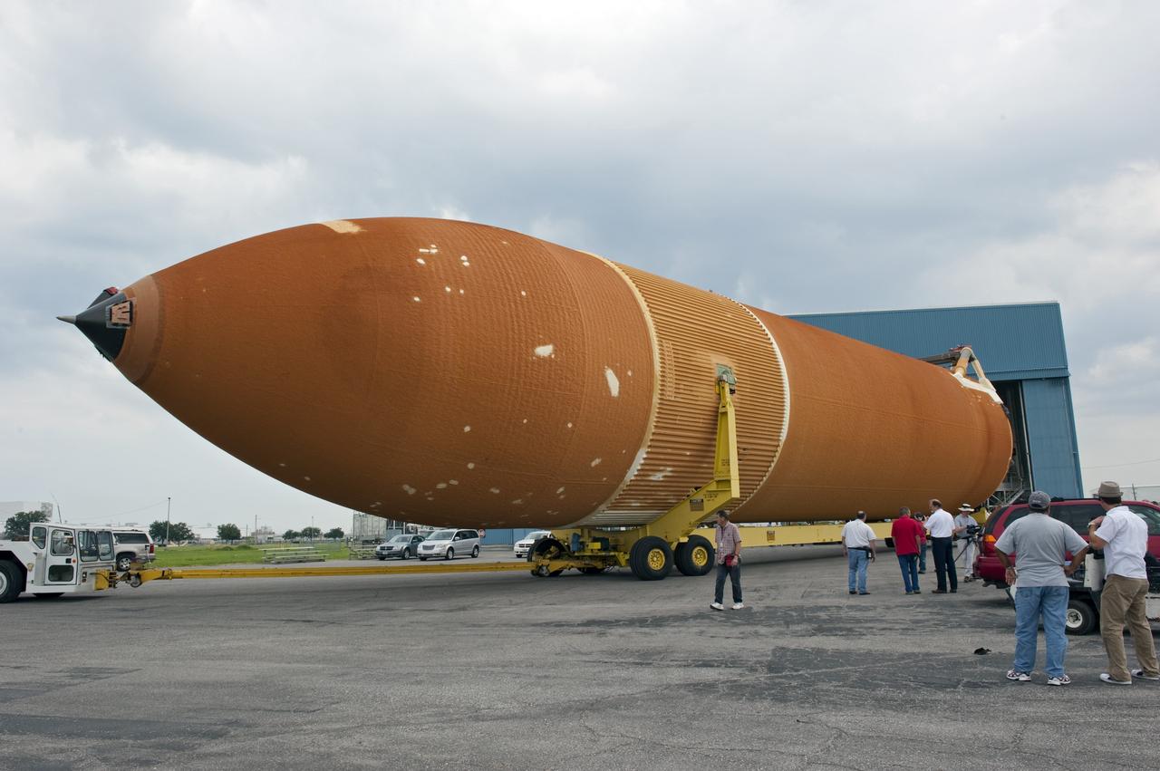 NEW ORLEANS -- Workers escort the Space Shuttle Program's last external fuel tank, ET-122, from NASA's Michoud Assembly Facility in New Orleans onto the Pegasus Barge. The tank will travel 900 miles by sea to NASA's Kennedy Space Center in Florida secured aboard the barge, offloaded and moved to Kennedy's Vehicle Assembly Building where it will be integrated to space shuttle Endeavour for the STS-134 mission to the International Space Station.      The tank, which is the largest element of the space shuttle stack, was damaged during Hurricane Katrina in August 2005 and restored to flight configuration by Lockheed Martin Space Systems Company employees. STS-134, targeted to launch Feb. 2011, currently is scheduled to be the last mission in the Space Shuttle Program. Photo credit: NASA/Kim Shiflett